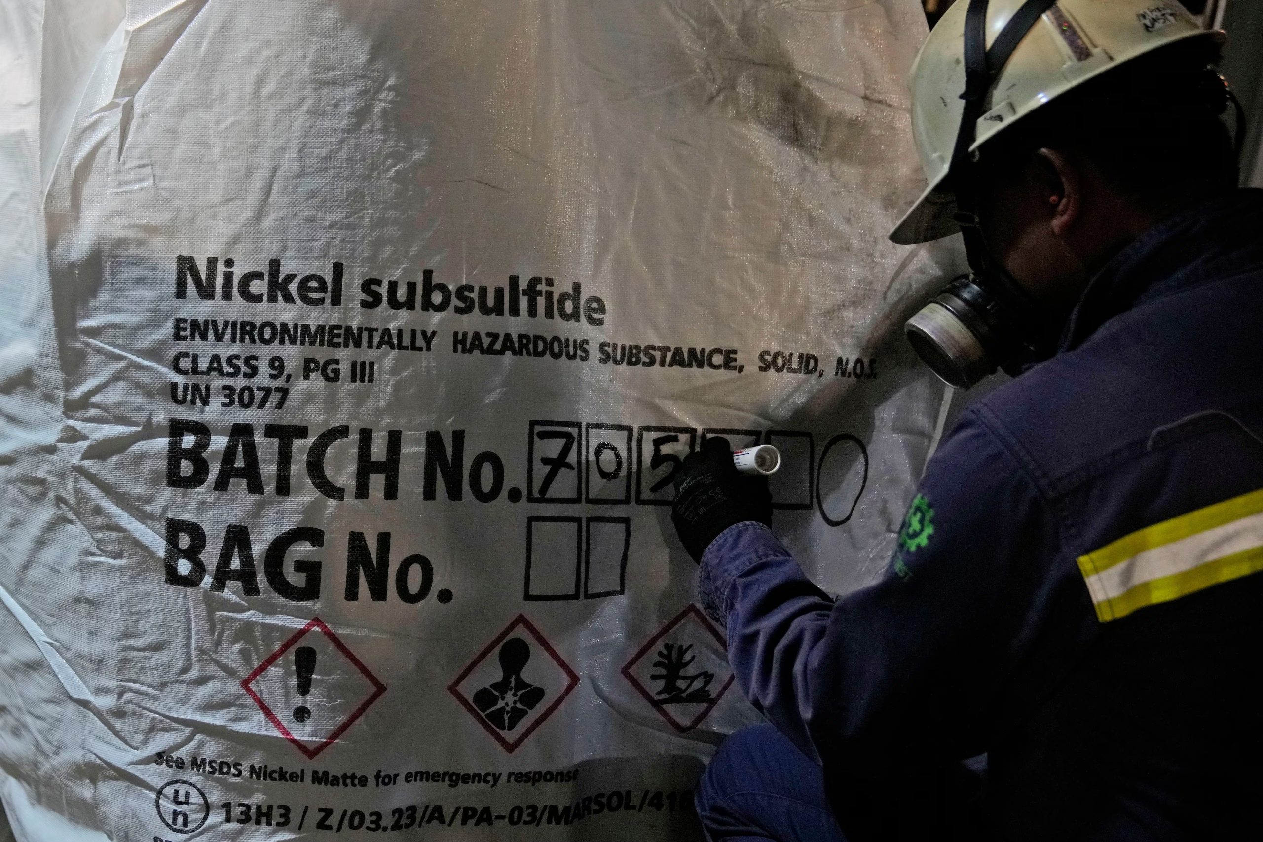 Un trabajador escribe números de lote en una bolsa de níquel mate en una planta procesadora en Sorowako, Sulawesi del Sur, Indonesia, el 12 de diciembre de 2023 (AP/Dita Alangkara/Archivo)