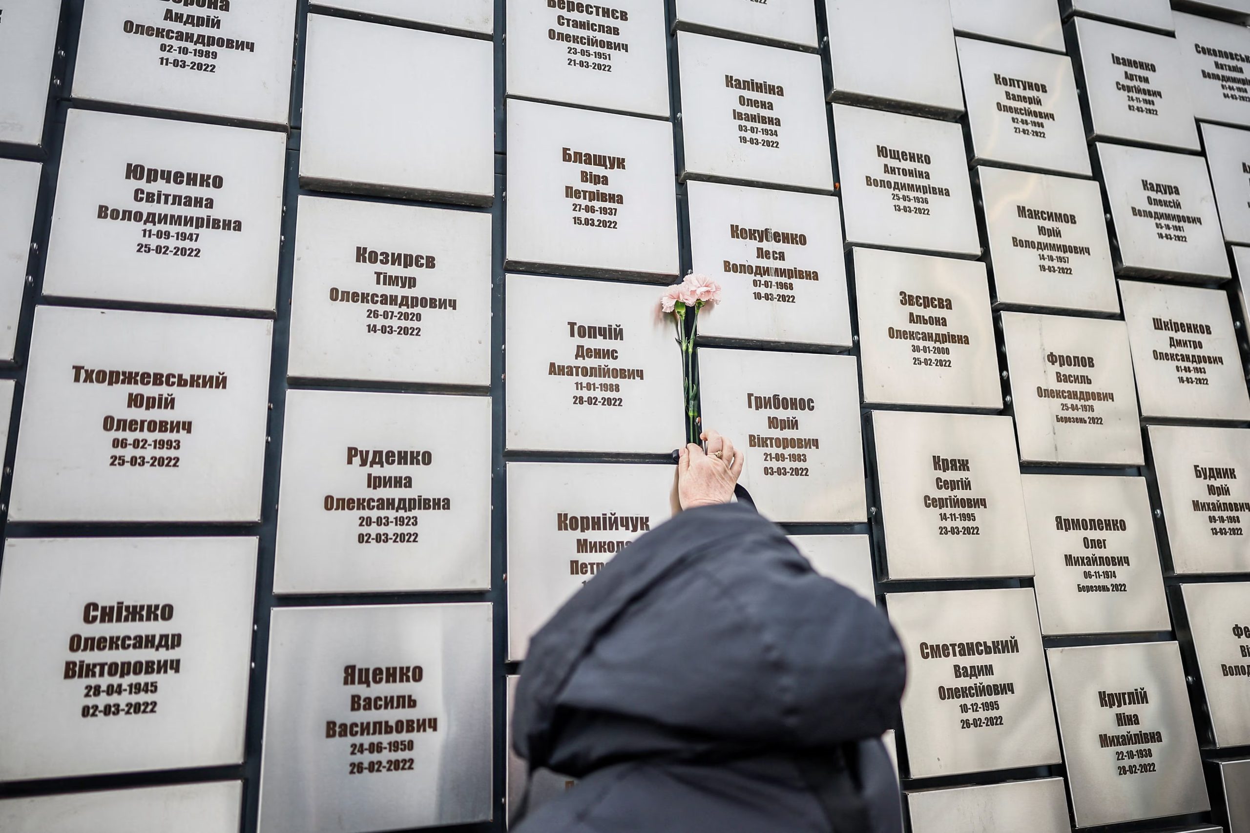 Una mujer lleva flores para rendir homenaje a la instalación conmemorativa en honor a las víctimas de los ataques y ejecuciones perpetrados por las tropas rusas, con motivo del cuarto aniversario de la invasión rusa a gran escala, en el marco del ataque de Rusia contra Ucrania, en la ciudad de Bucha, región de Kiev, Ucrania, el 24 de febrero de 2026. REUTERS/Alina Smutko