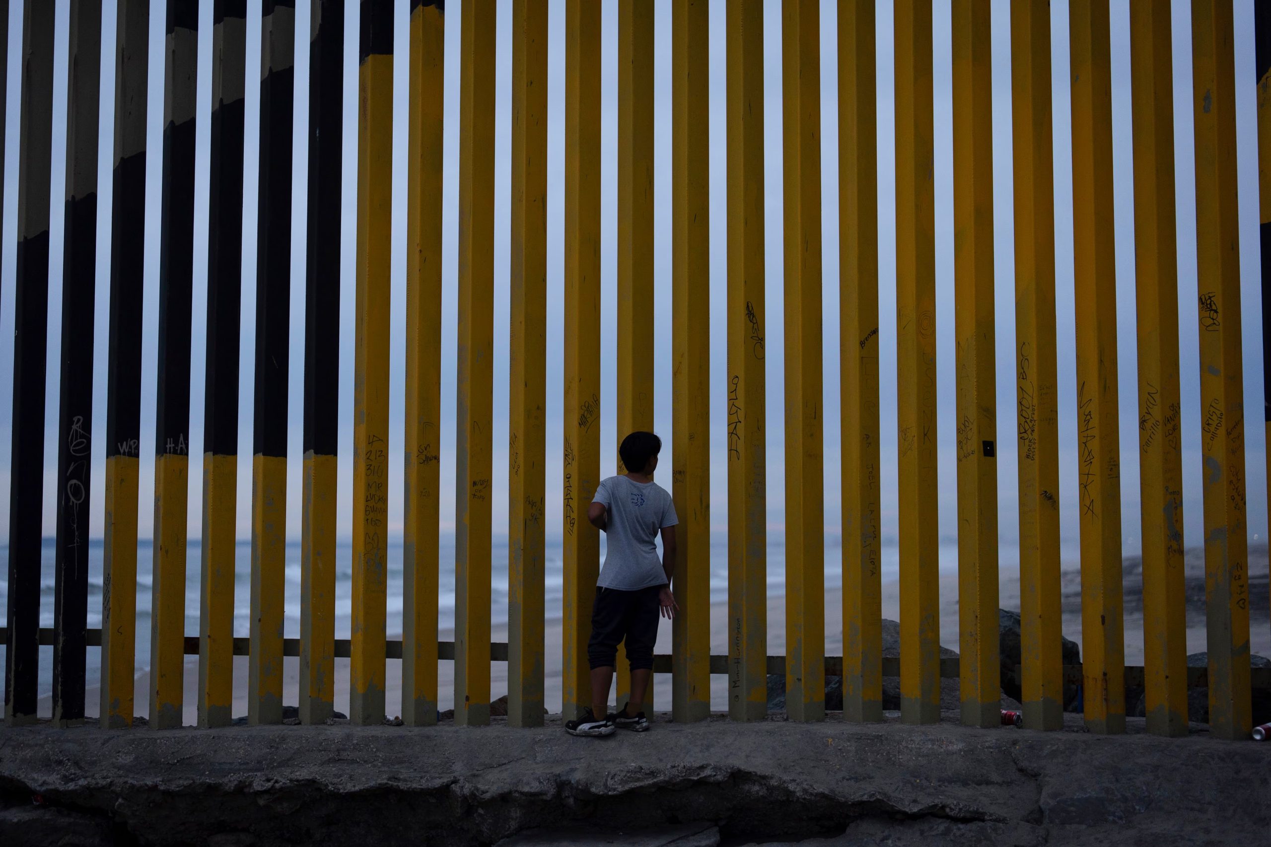 Un niño observa a través del muro fronterizo que separa a México de Estados Unidos, el 26 de noviembre de 2024, en Tijuana, México. (AP Foto/Gregory Bull, Archivo)
