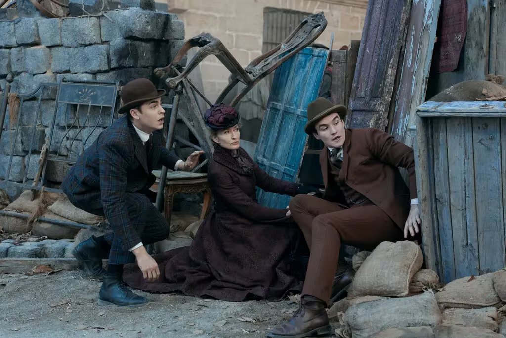 Fiennes Tiffin con Natascha McElhone y Dónal Finn, quien interpreta a James Moriarty. La serie convierte al némesis de Holmes en su compañero y cómplice en la resolución de crímenes