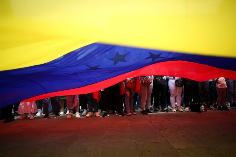 FOTO DE ARCHIVO: Venezolanos residentes en Colombia sostienen la bandera nacional de Venezuela | REUTERS/Juan David Duque/Archivo