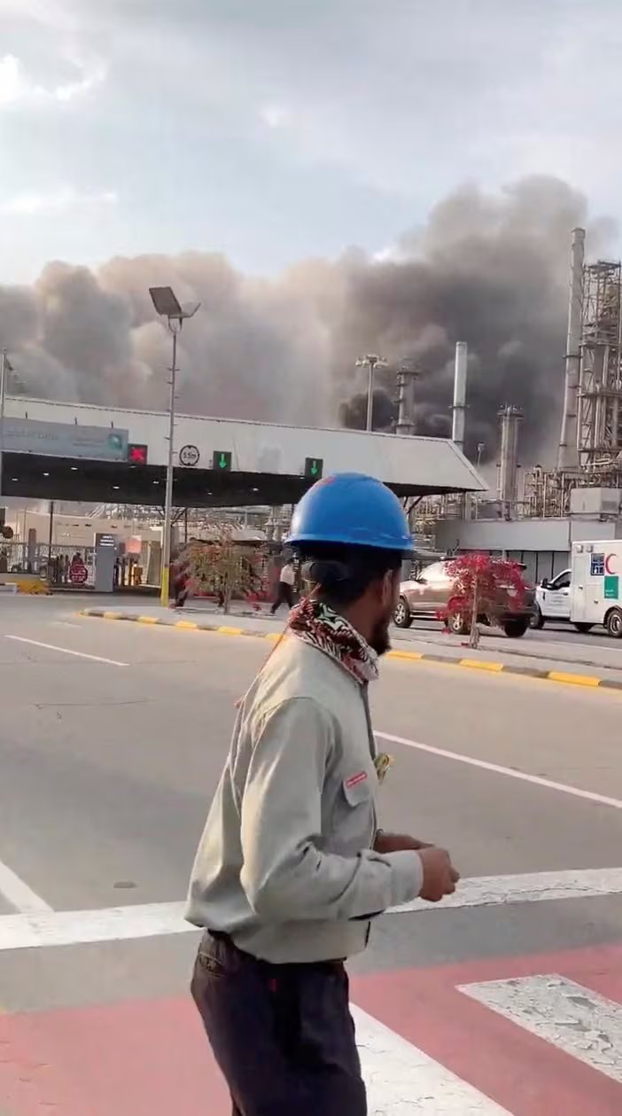 Los trabajadores evacúan la zona alrededor de la refinería de petróleo Ras Tanura de Saudi Aramco mientras se eleva el humo tras un supuesto ataque con drones iraníes, en Ras Tanura, Arabia Saudita, en esta imagen fija obtenida de un video publicado en redes sociales el 2 de marzo de 2026. Redes sociales/vía REUTERS 