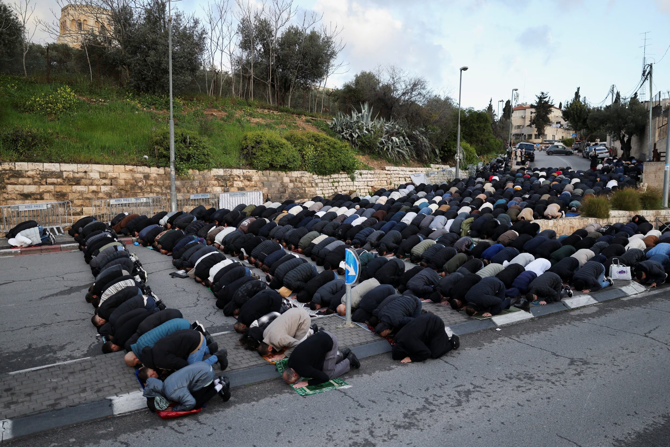 Fieles musulmanes palestinos rezan junto a una carretera para conmemorar el final del mes sagrado de Ramadán, en Jerusalén (REUTERS/Ammar Awad)