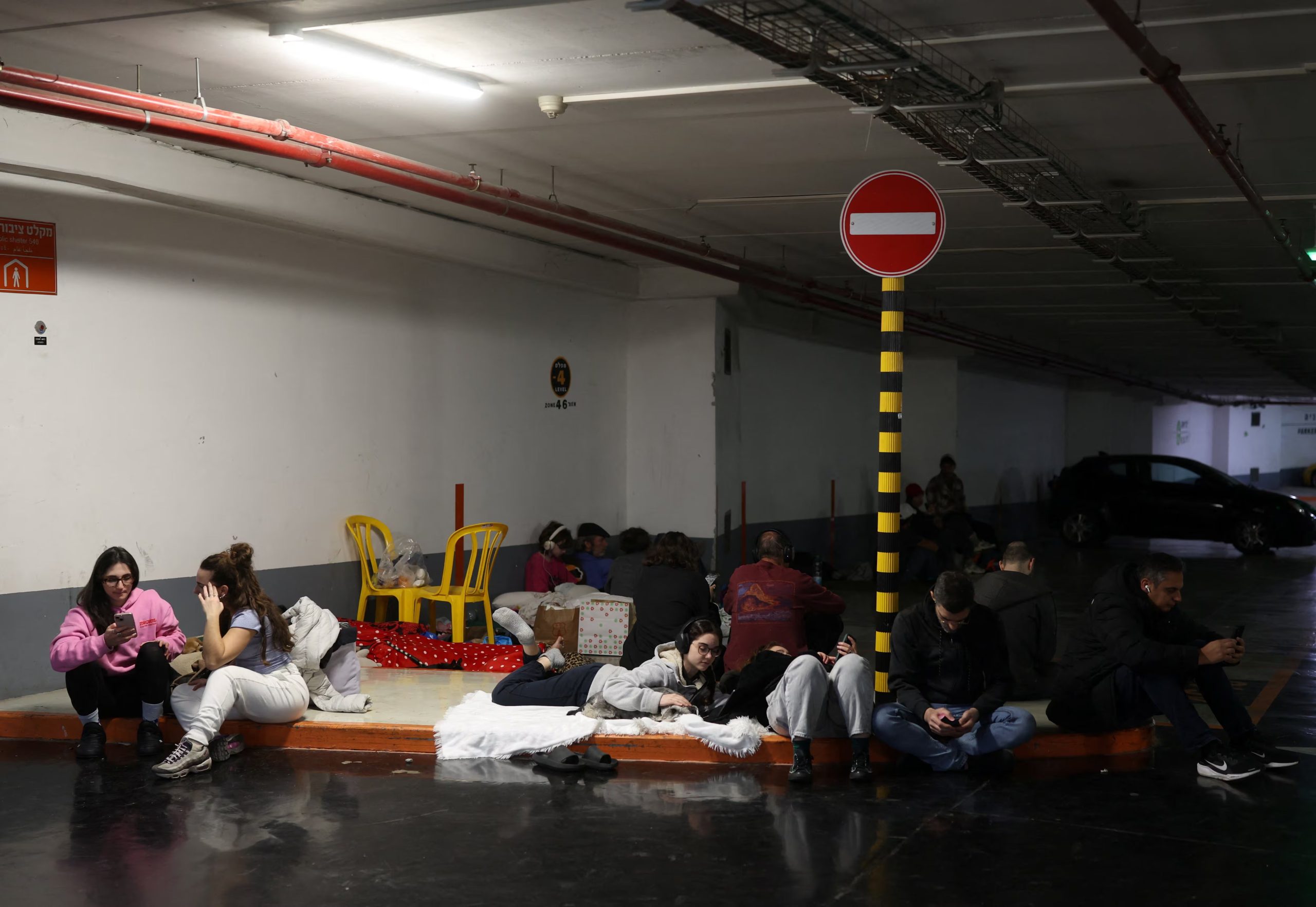 Personas se refugian en un estacionamiento durante un ataque iraní, después de que Irán lanzara andanadas de misiles en Tel Aviv, Israel (REUTERS/Ronen Zvulun)