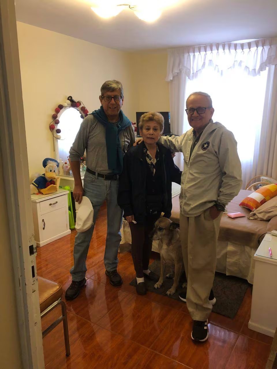 La reconocida actriz Irma Maury, conocida por su papel de ‘Doña Nelly’ en AFHS, sonríe junto a dos hombres y un perro, evidenciando su buena recuperación tras un grave accidente. (Irma Maury)