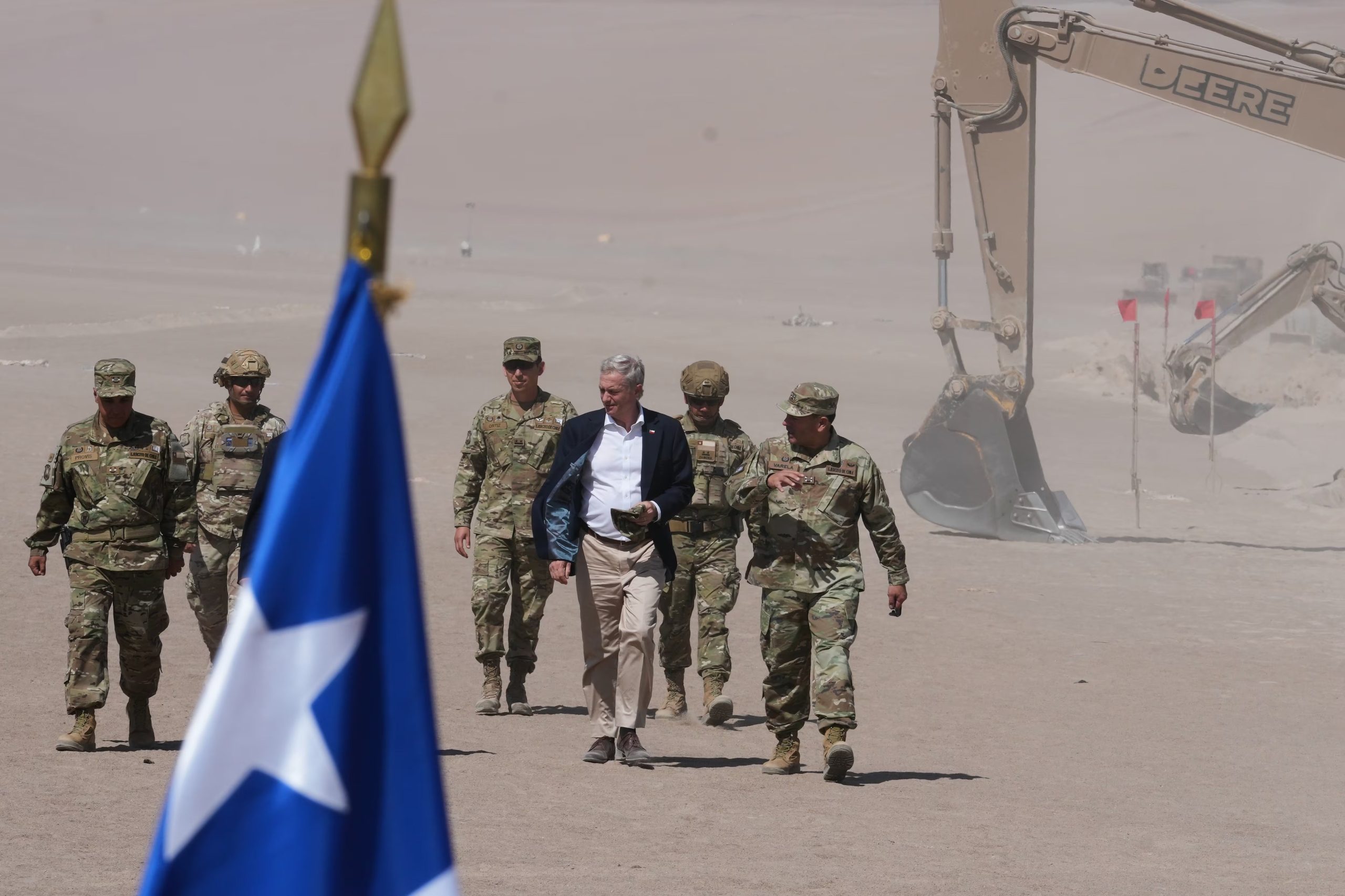 El presidente chileno José Antonio Kast camina junto a las excavadoras a lo largo de la frontera norte en el cruce de Chacalluta en Arica, Chile, el lunes 16 de marzo de 2026, como parte de las medidas para disuadir la migración irregular. (AP Foto/Esteban Félix)