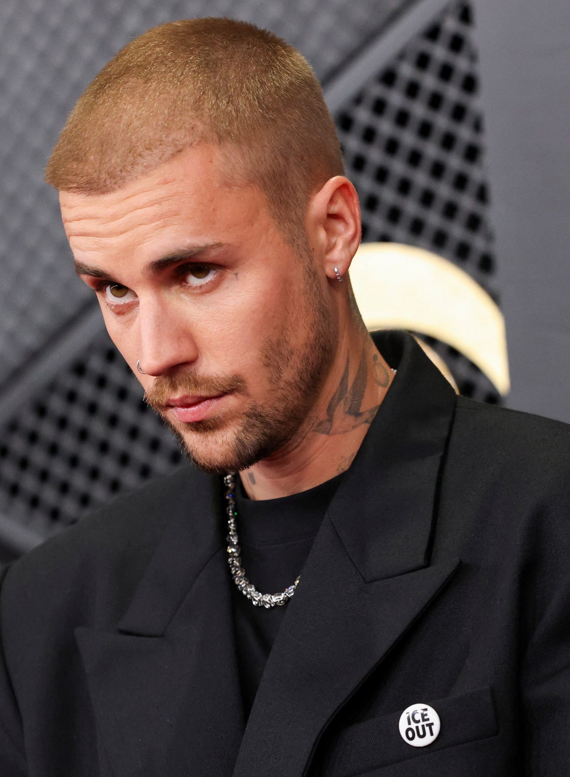 El saco negro de solapa ancha, combinado con camiseta básica y accesorios metálicos, refleja la sofisticación contemporánea que caracteriza el estilo de Justin Bieber en sus eventos más formales (REUTERS/Mario Anzuoni)