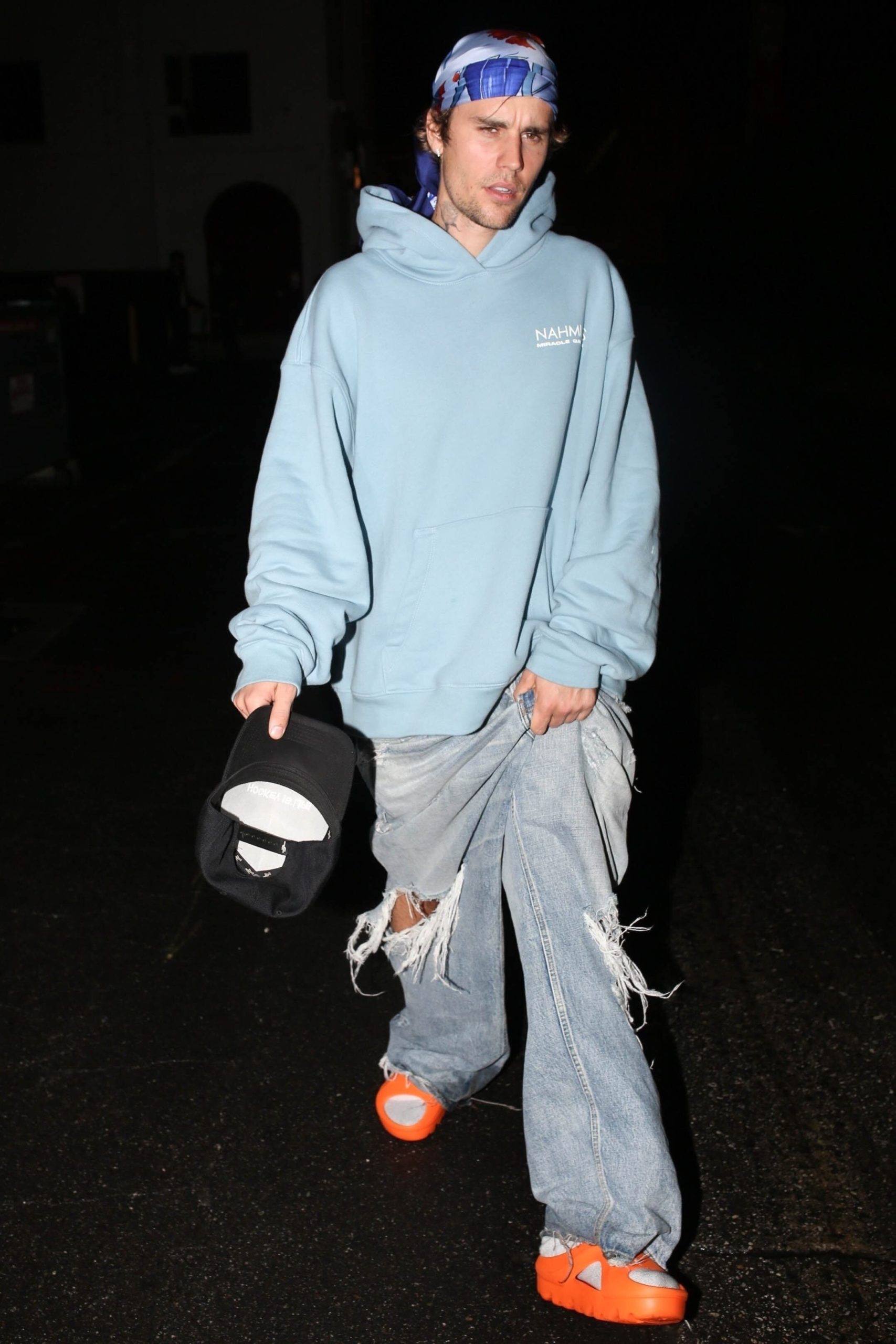 El saco gris oversize, la camiseta blanca y el gorro fucsia definen un look de estructura amplia y toques vibrantes, complementado por gafas oscuras que aportan misterio y modernidad (The Grosby Group)