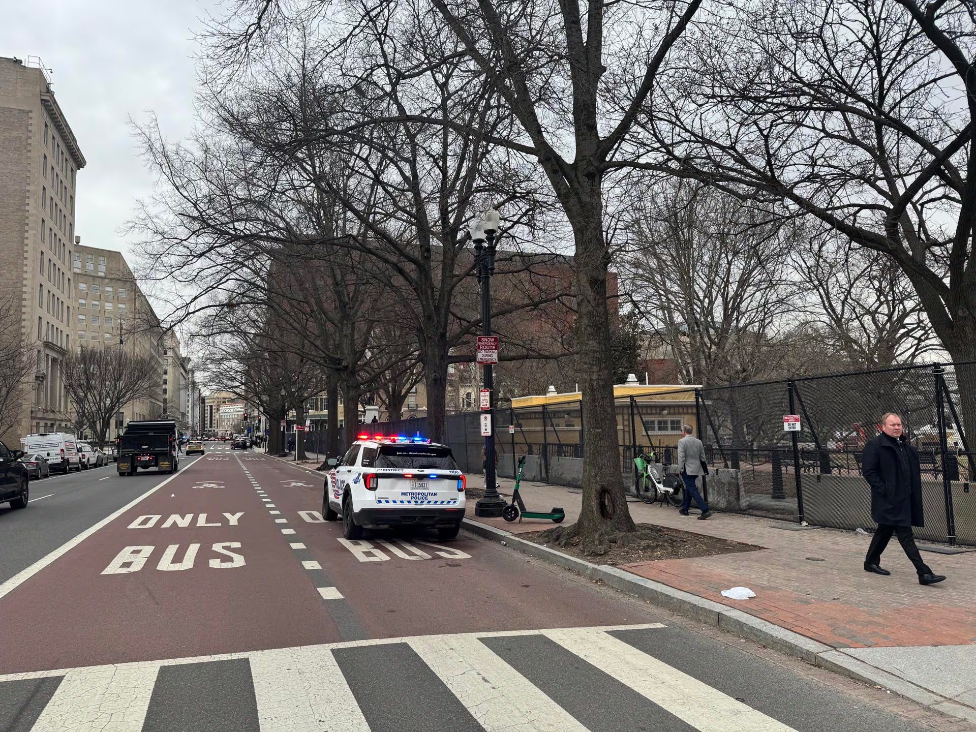 Un vehículo de la Policía Metropolitana con luces de emergencia activadas se encuentra estacionado en una calle de Washington, indicando una presencia de seguridad en el área.