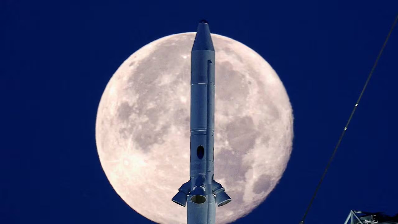 El cohete de la misión Artemis I, parte del programa Artemis, se ve imponente frente a la Luna llena, listo para su histórico viaje espacial. (Reuters)