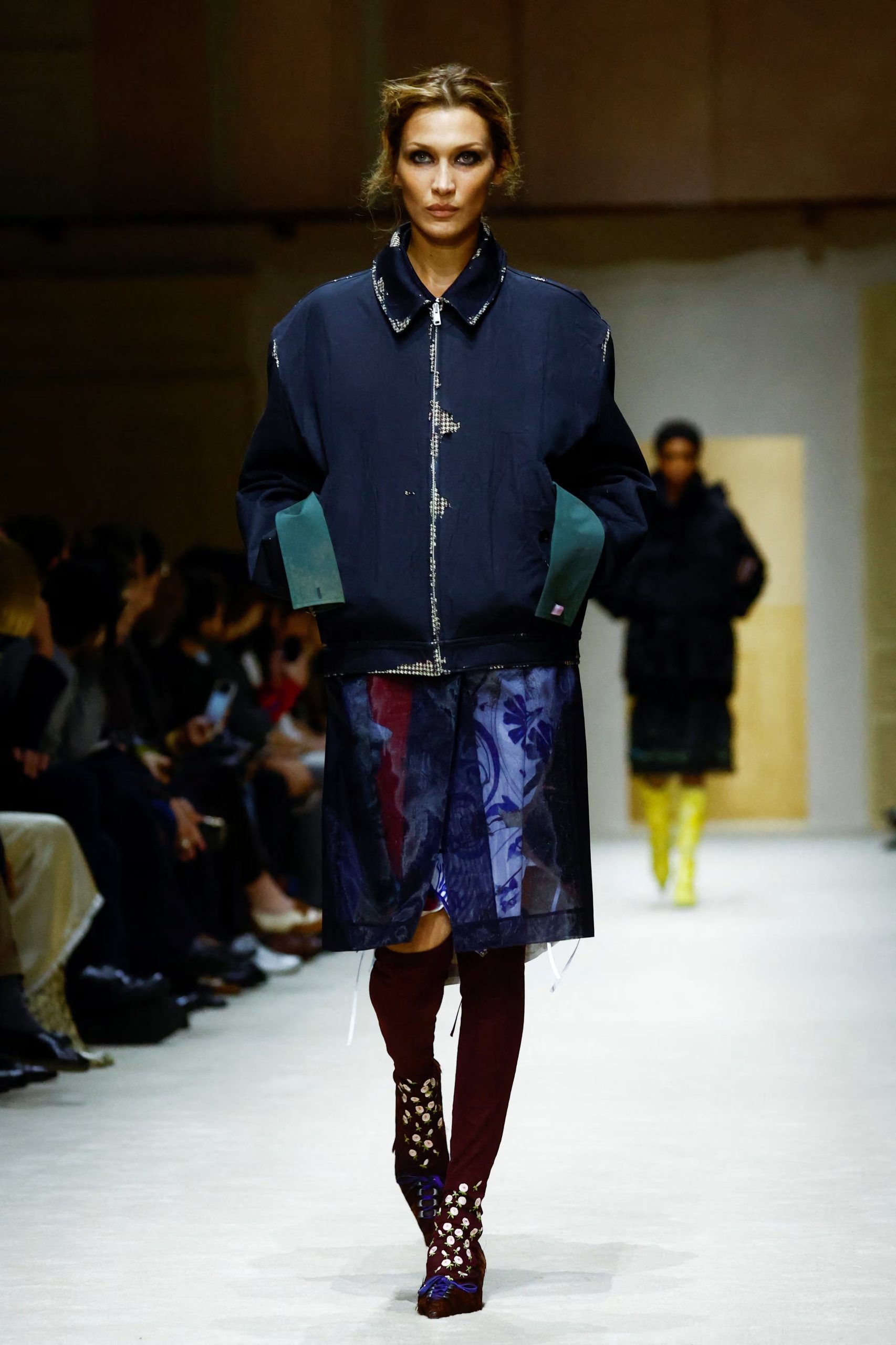 Bella Hadid con pollera a la rodilla translúcida y estampada en tonos azules y morados en un desfile de Prada (REUTERS/Alessandro Garofalo)