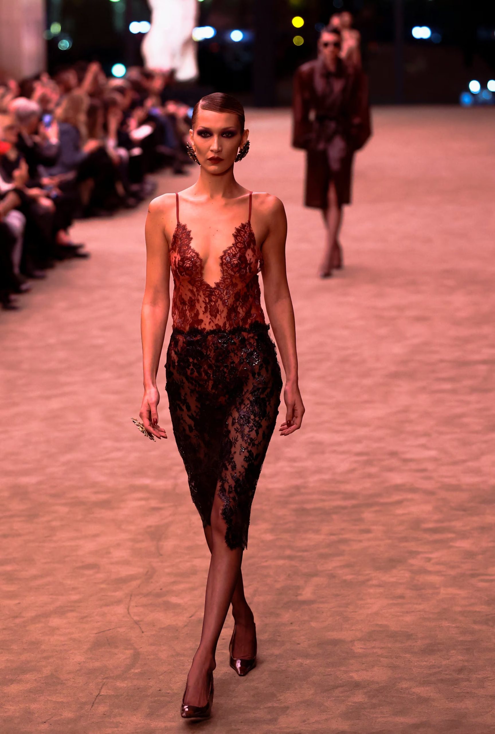 Bella Hadid con pollera midi de encaje negro y abertura frontal en el desfile de Saint Laurent (REUTERS/Stephane Mahe)