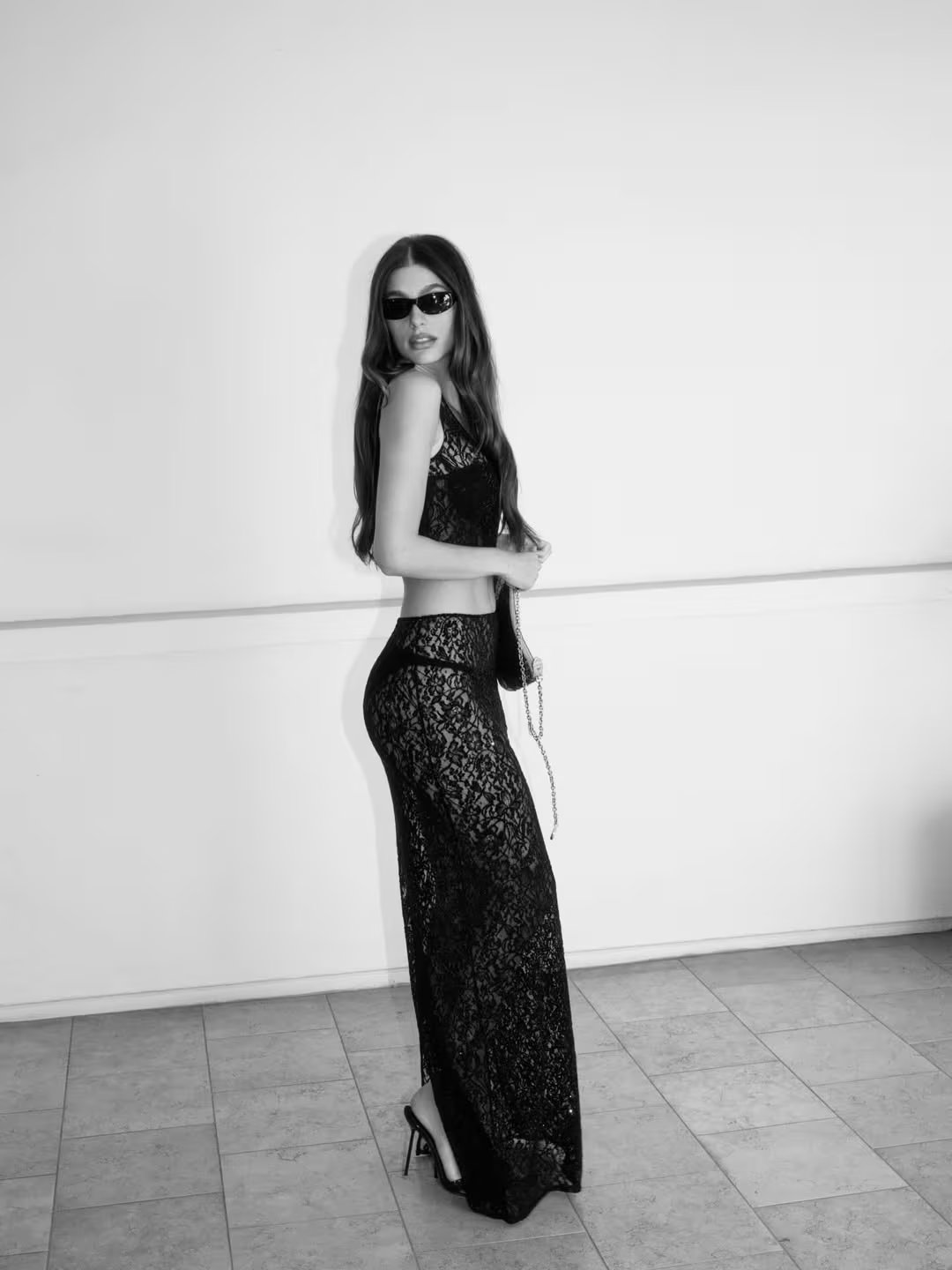 Camila Morrone con pollera larga de encaje negro y top a juego en un evento de moda