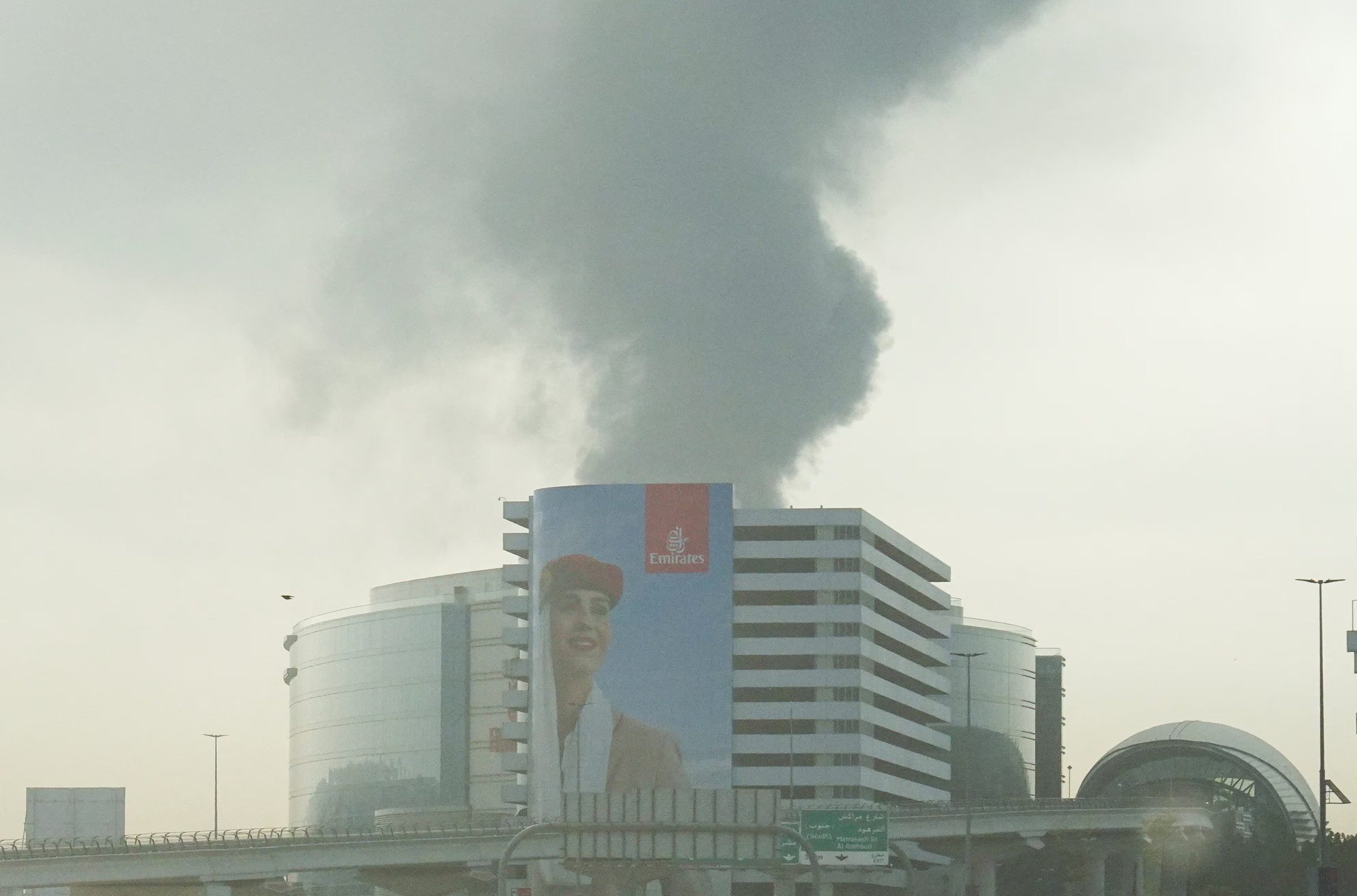 Se observa humo saliendo del Aeropuerto Internacional de Dubái a través del parabrisas de un vehículo, luego de que un dron impactara un tanque de combustible, según las autoridades de Dubái, en medio del conflicto entre Estados Unidos, Israel e Irán, en Dubái, Emiratos Árabes Unidos, 16 de marzo de 2026, REUTERS/Stringer
