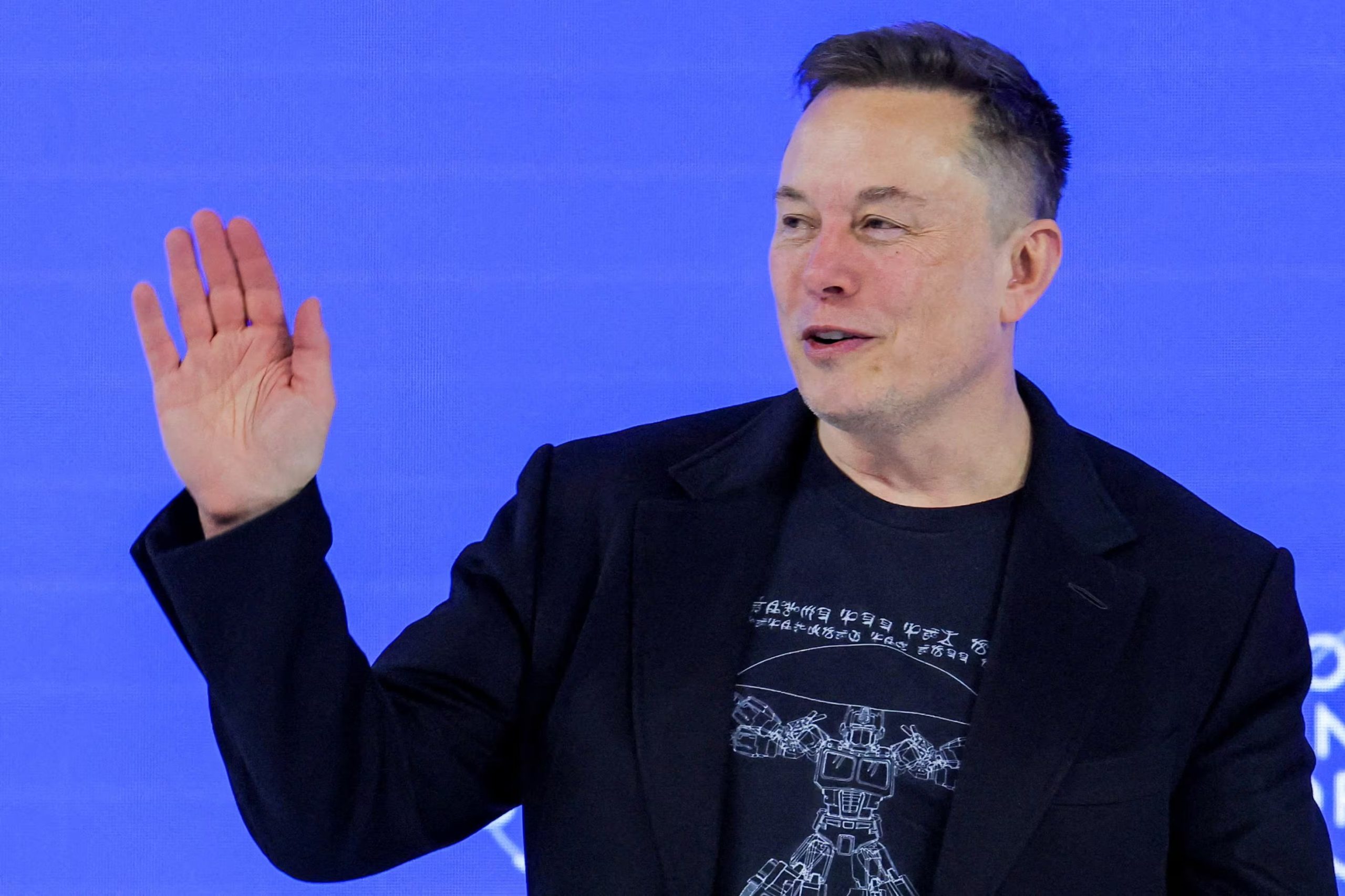 FILE PHOTO: Elon Musk waves to the crowd during the 56th annual World Economic Forum (WEF) meeting in Davos, Switzerland, January 22, 2026. REUTERS/Denis Balibouse/File Photo