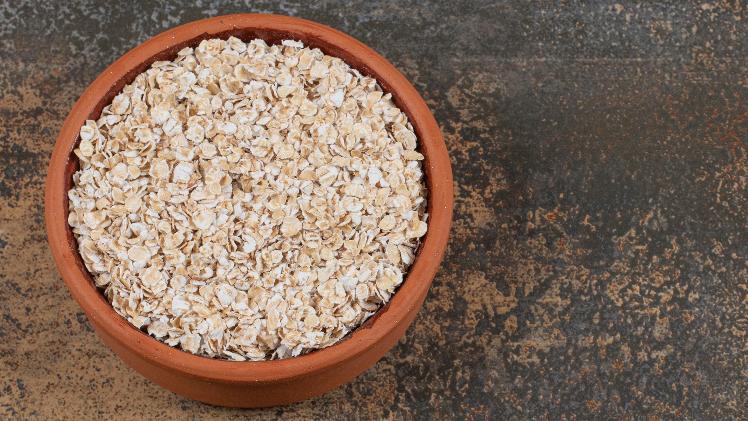 Un tazón de avena laminada, lista para ser preparada como un desayuno nutritivo o incorporada en diversas recetas saludables, resalta su importancia en una dieta equilibrada.