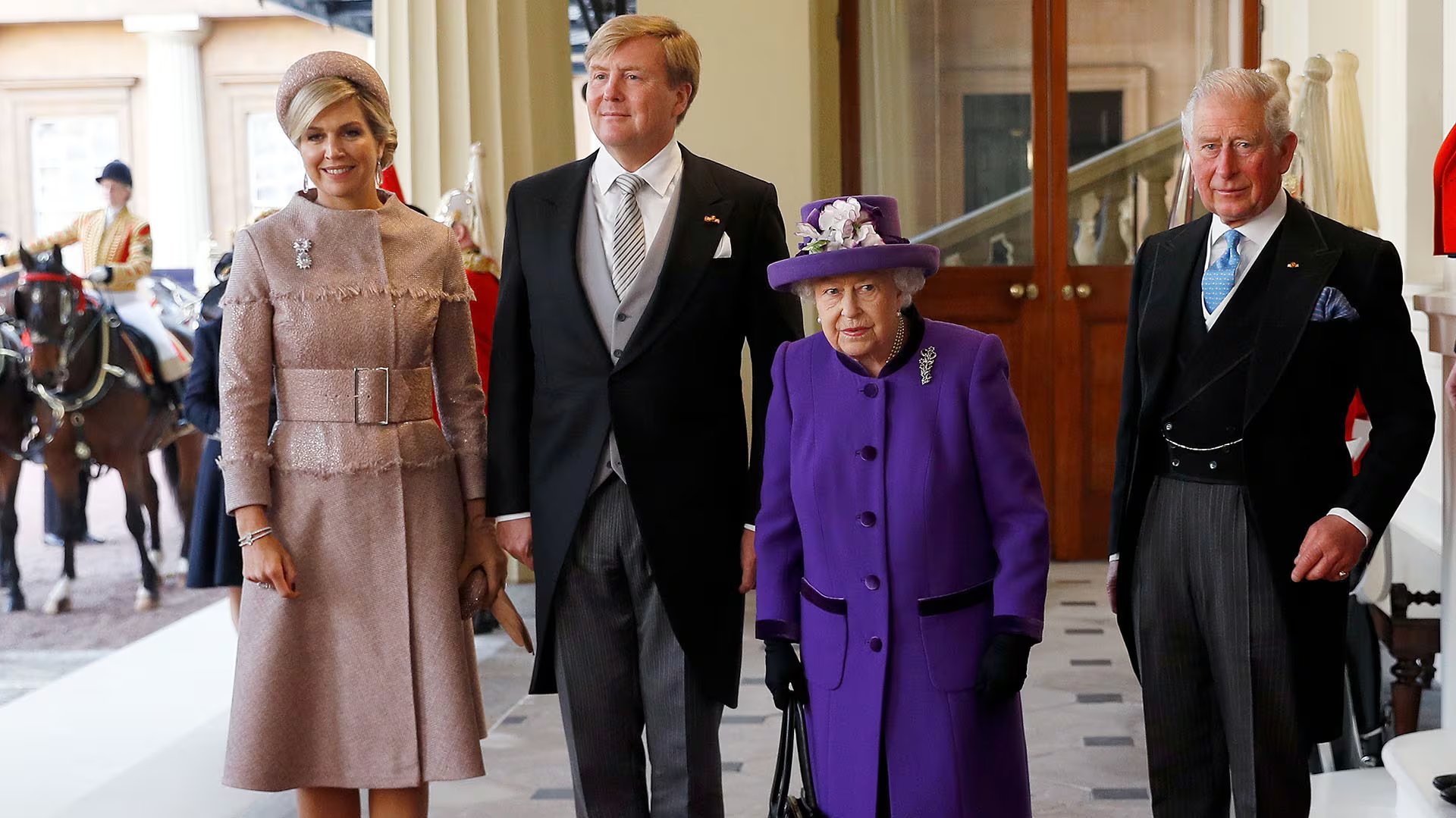 El sombrero violeta de la reina Isabel II, decorado con flores blancas y lilas, se convirtió en un símbolo de su imagen reconocida y de la impecable coordinación en eventos de Estado (REUTERS)