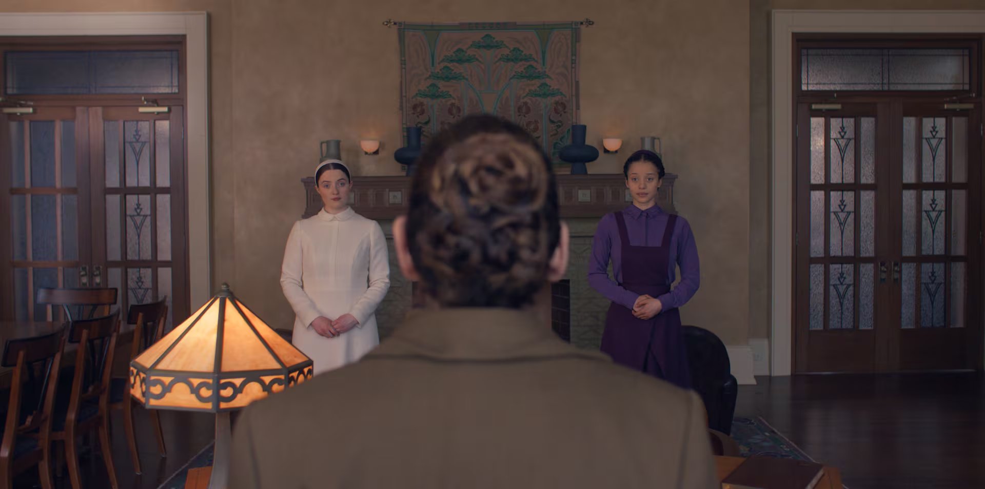 La actriz Lucy Halliday, vestida de blanco, y Chase Infinity vestida de púrpura en 'Los testamentos' (Disney Plus)