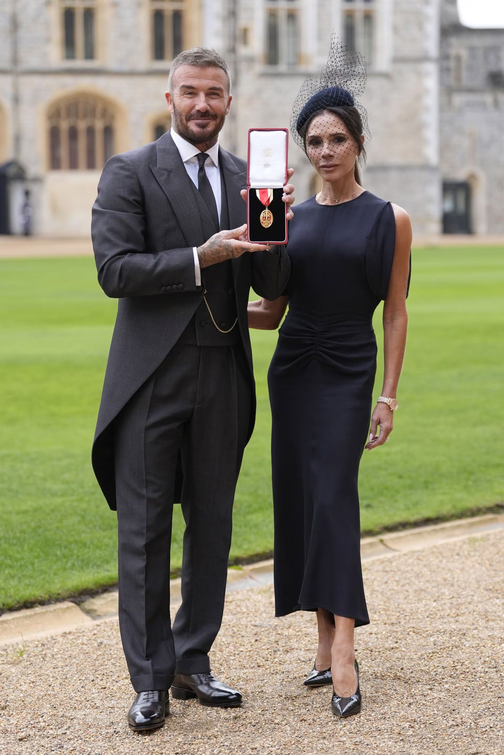 El tocado azul marino y el vestido midi negro aportan un aire enigmático al estilo de Victoria Beckham (Grosby)