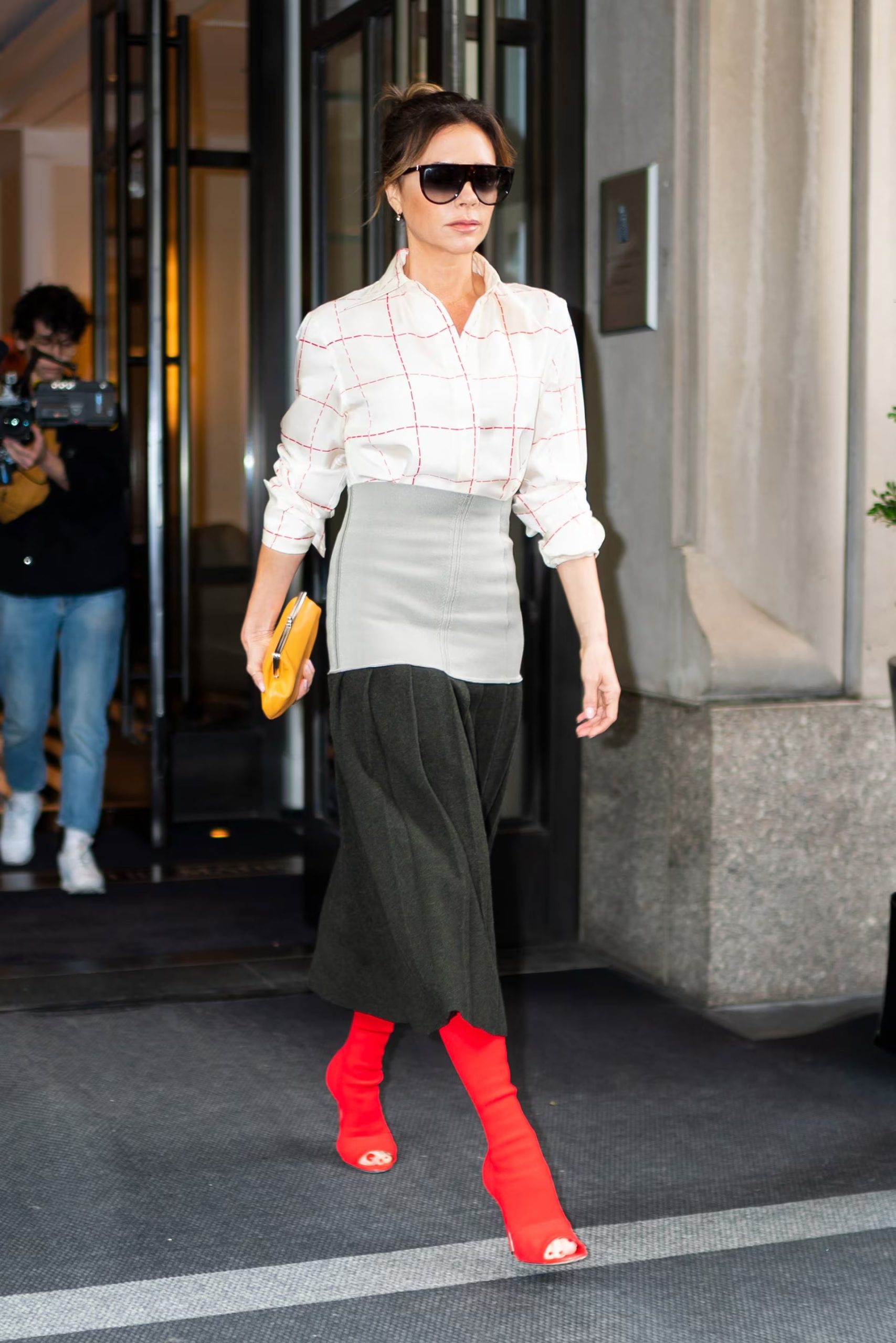 Sandalias rojas y falda midi gris resaltan la creatividad y el colorido de Victoria Beckham (Photo by Gotham/GC Images)