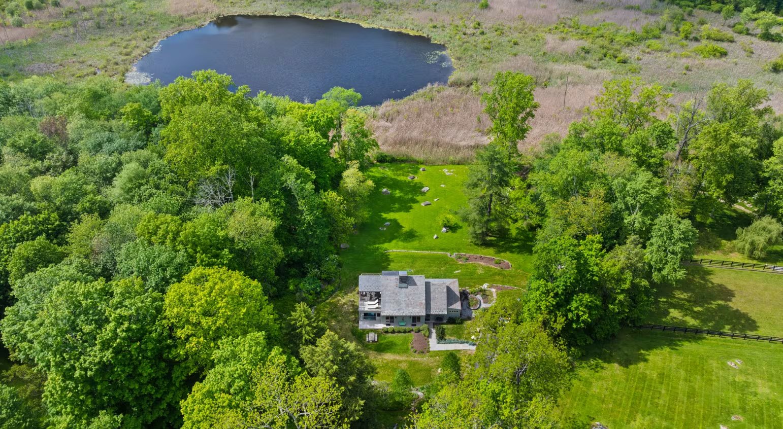 Jardines y estanque que aportan privacidad y un entorno sereno a la vivienda listada por Ginnel Real Estate.