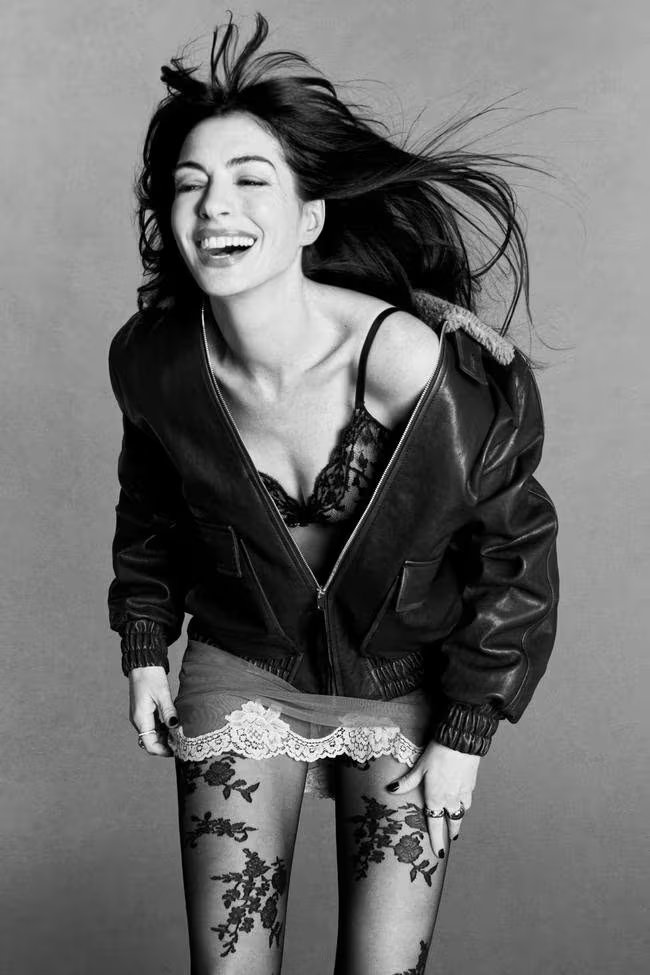  Hathaway une una chaqueta bomber de cuero y minifalda de encaje, mientras una risa abierta y medias bordadas ponen en primer plano la autenticidad como tendencia (Vogue)