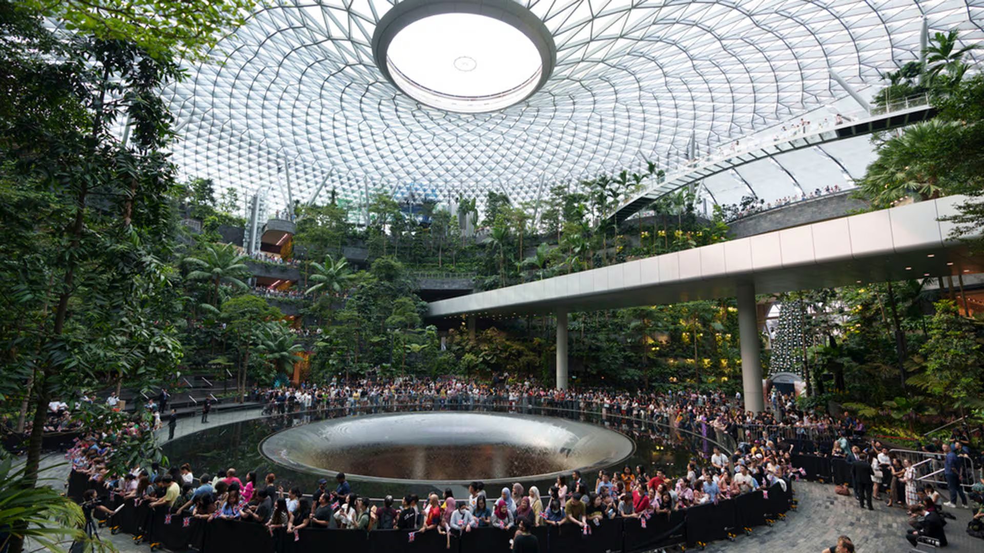 El agua cae desde el techo de vidrio y está rodeada por un extenso jardín interior con miles de plantas y árboles. (AP Photo/Vincent Thian)