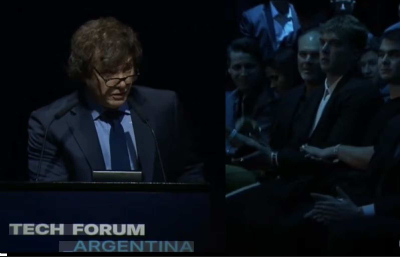 Milei habla en el Techo Forum el 19 de octubre de 2024, con Hayden Davis aplaudiendo en primera fila