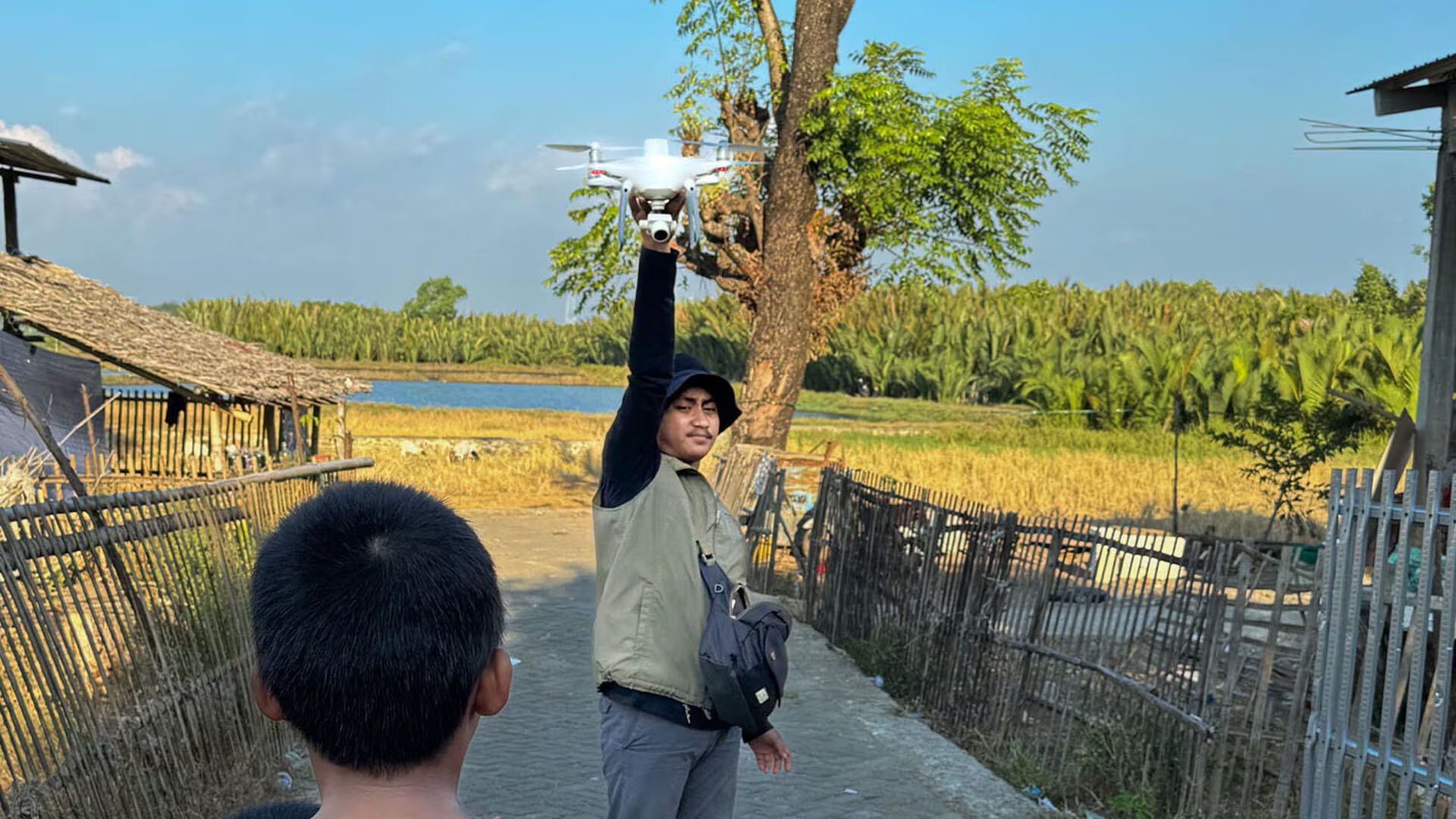 Muh. Yusuf Fadhel Marwiji, piloto local de drones en Makassar, Indonesia, se prepara para lanzar un dron en busca de neumáticos desechados que acumulan agua de lluvia y se convierten en criaderos de mosquitos, mientras un niño curioso observa.
Crédito: Universidad de Stanford / Morgan Tarpenning