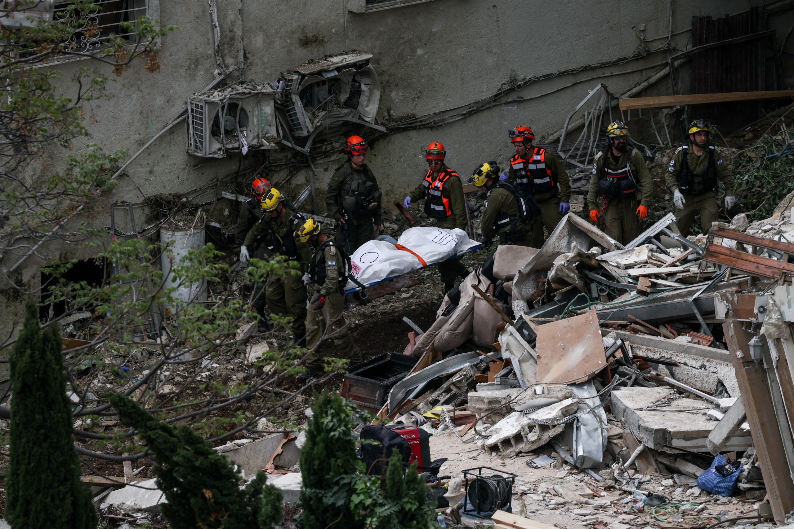 Personal de emergencia retira un cuerpo del sitio del impacto en Haifa. Desde el inicio del conflicto el 28 de febrero, 18 civiles han muerto en suelo israelí por ataques con misiles balísticos iraníes. (REUTERS/Shir Torem)