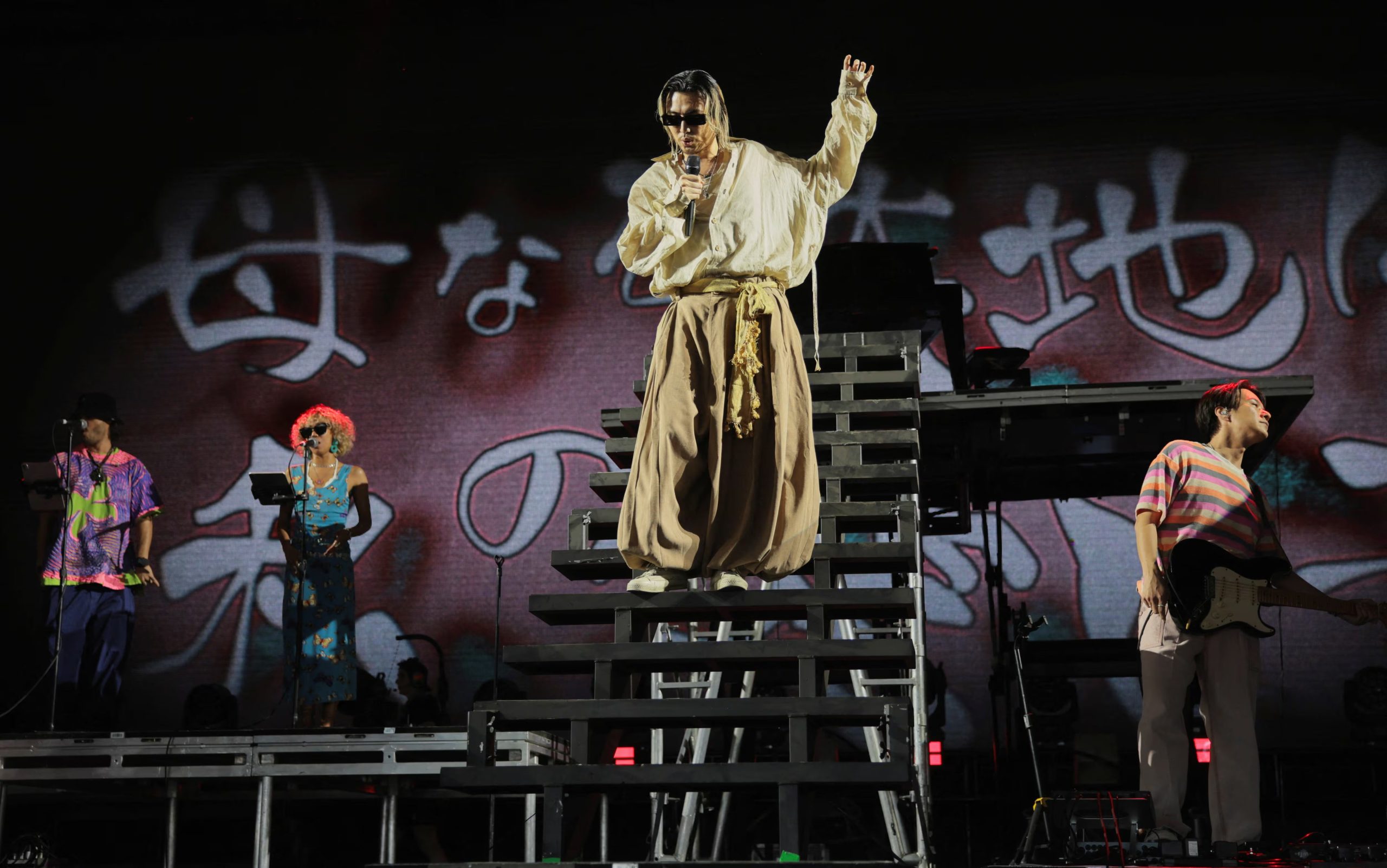 Fujii Kaze lució una blusa marfil y pantalones beige amplios, mientras su banda llevó estampados y colores vivos, fusionando estilos orientales y modernos (REUTERS/Daniel Cole)