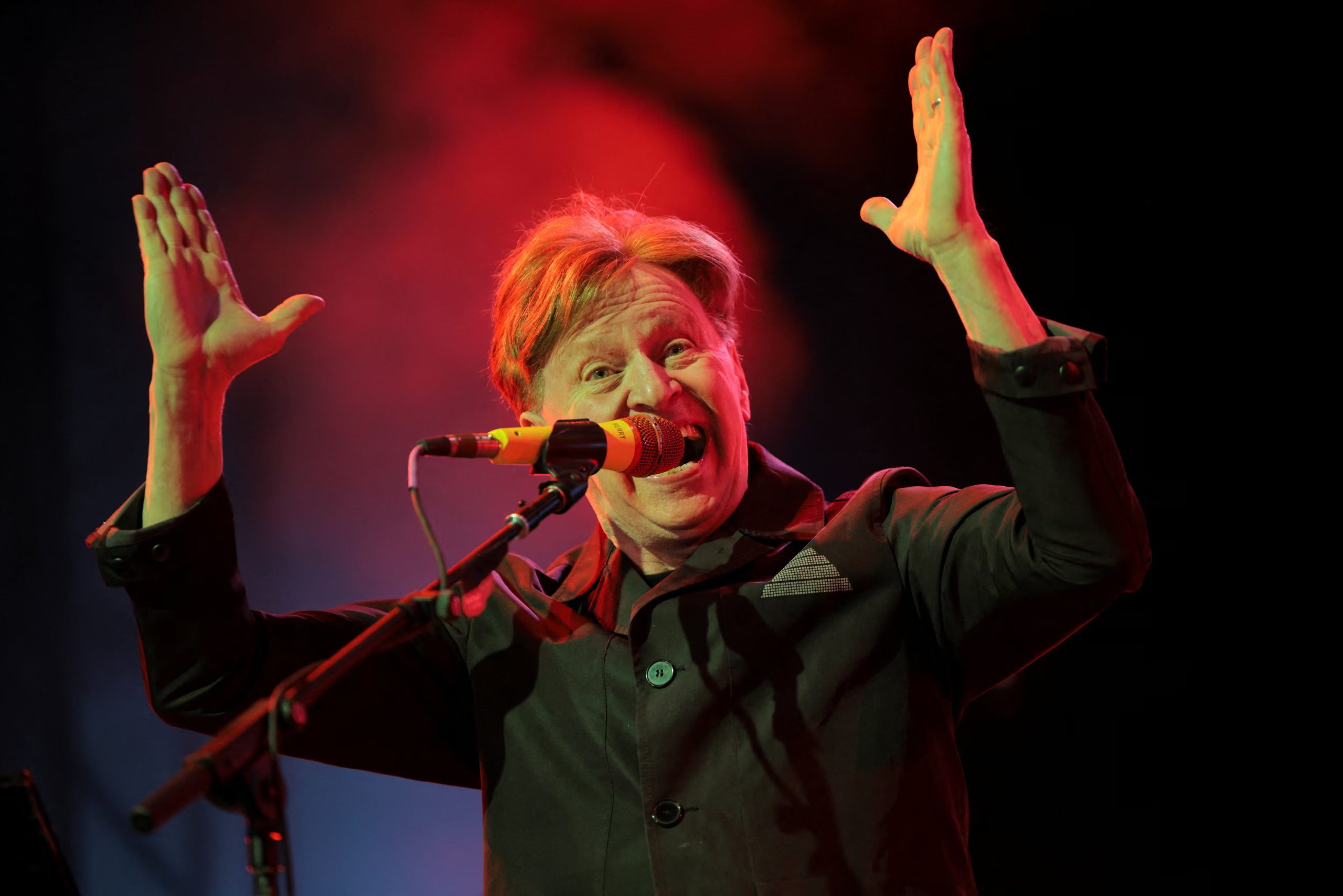 Gerald Casale eligió la sobriedad total con un saco negro de solapa ancha y camisa a juego, peinando su cabello de lado para una presentación elegante (REUTERS/Daniel Cole)