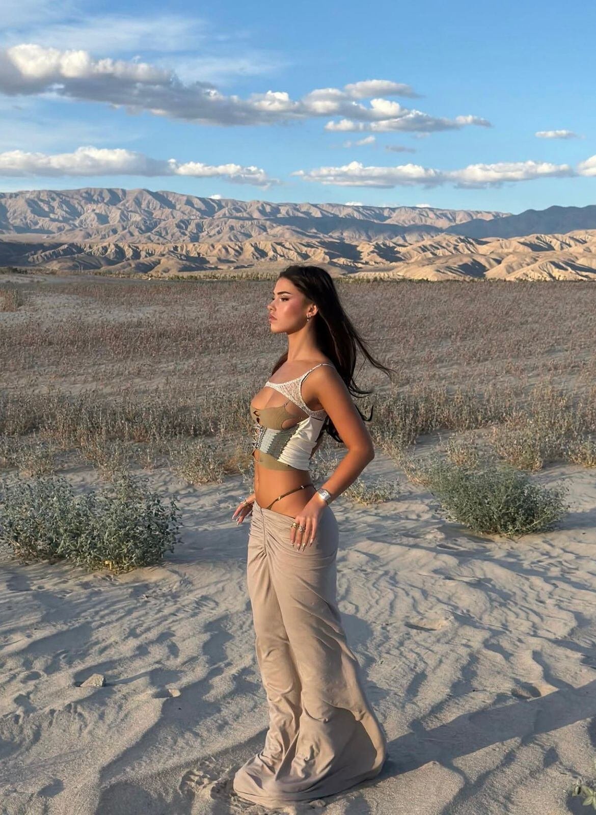 Leah Halton optó por un top de tirantes finos en beige y verde oliva, combinado con una pollera larga color arena de tela ligera, resaltando detalles translúcidos y un diseño fruncido central (Instagram Leah Halton)