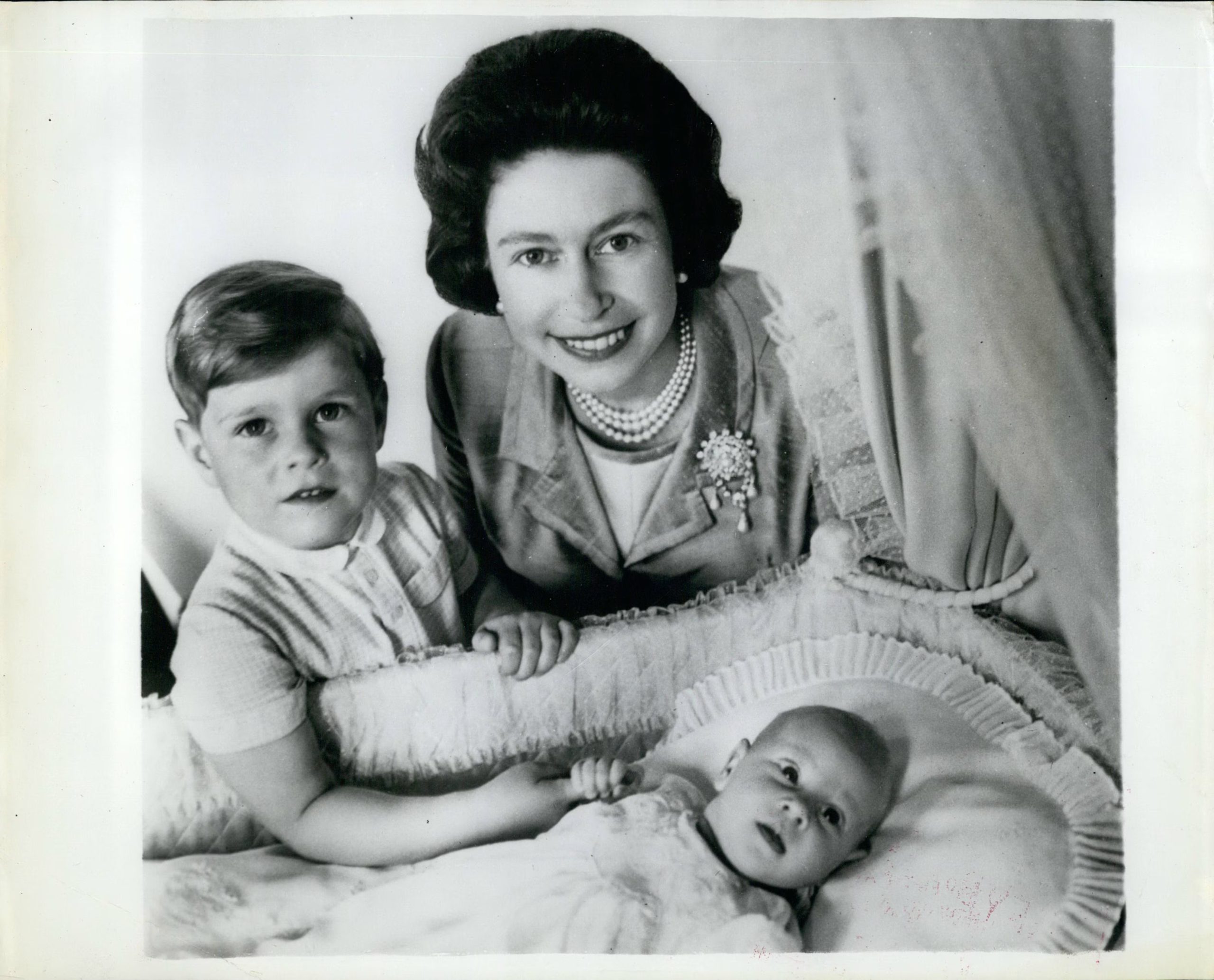 Isabel II y el príncipe Andrés, de cuatro años, aparecen en la cuna de Eduardo, el cuarto hijo de la reina, nacido el 10 de marzo de 1964. (2020 Zuma Press/The Grosby Group)