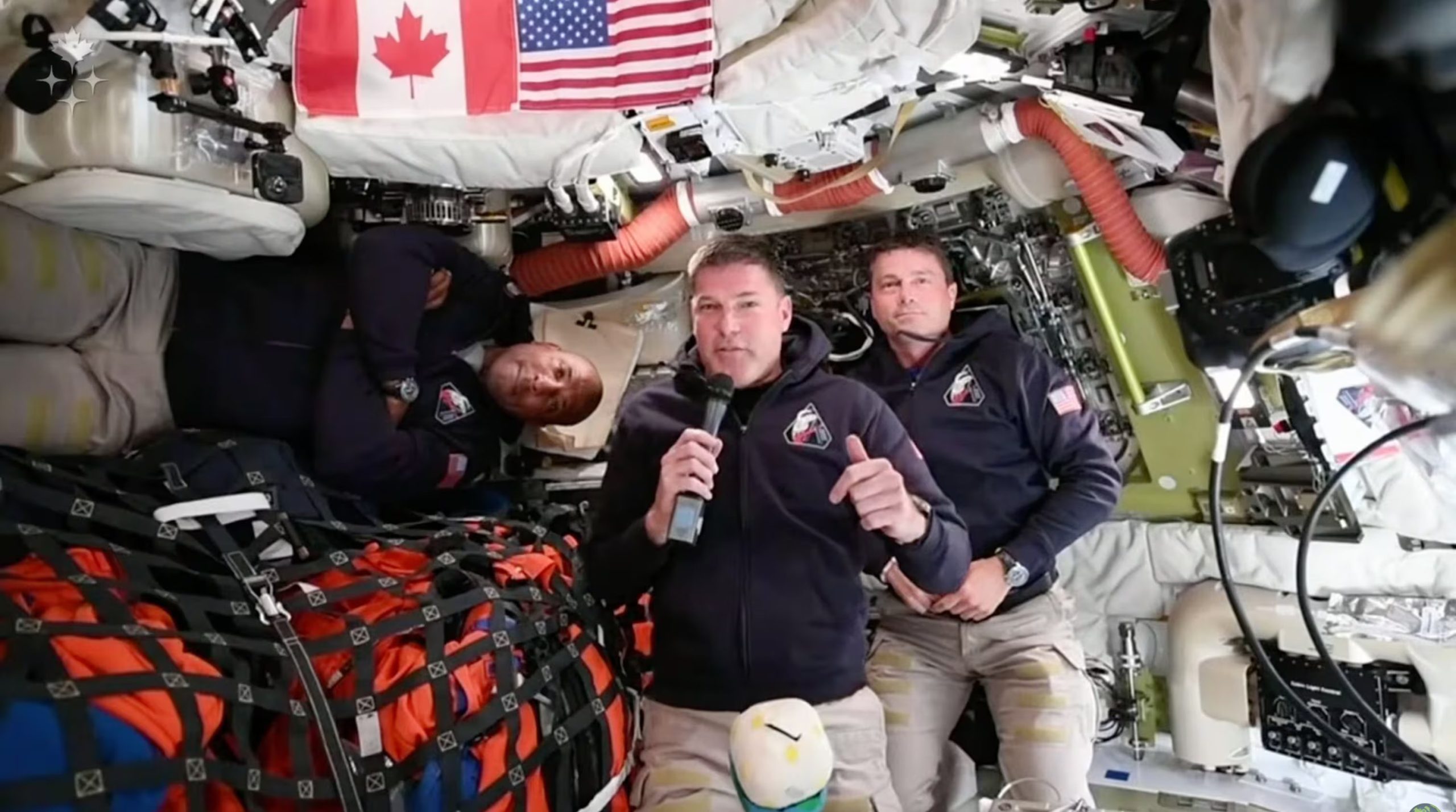 En la imagen, proporcionada por la Agencia Espacial Canadiense, el astronauta de Artemis II Jeremy Hansen, de origen canadiense, se conecta en vivo desde la nave espacial Orion y habla con medios canadienses junto con los astronautas Victor Glover, izquierda, y Reid Wiseman, el sábado 4 de abril de 2026. (Agencia Espacial Canadiense vía AP)