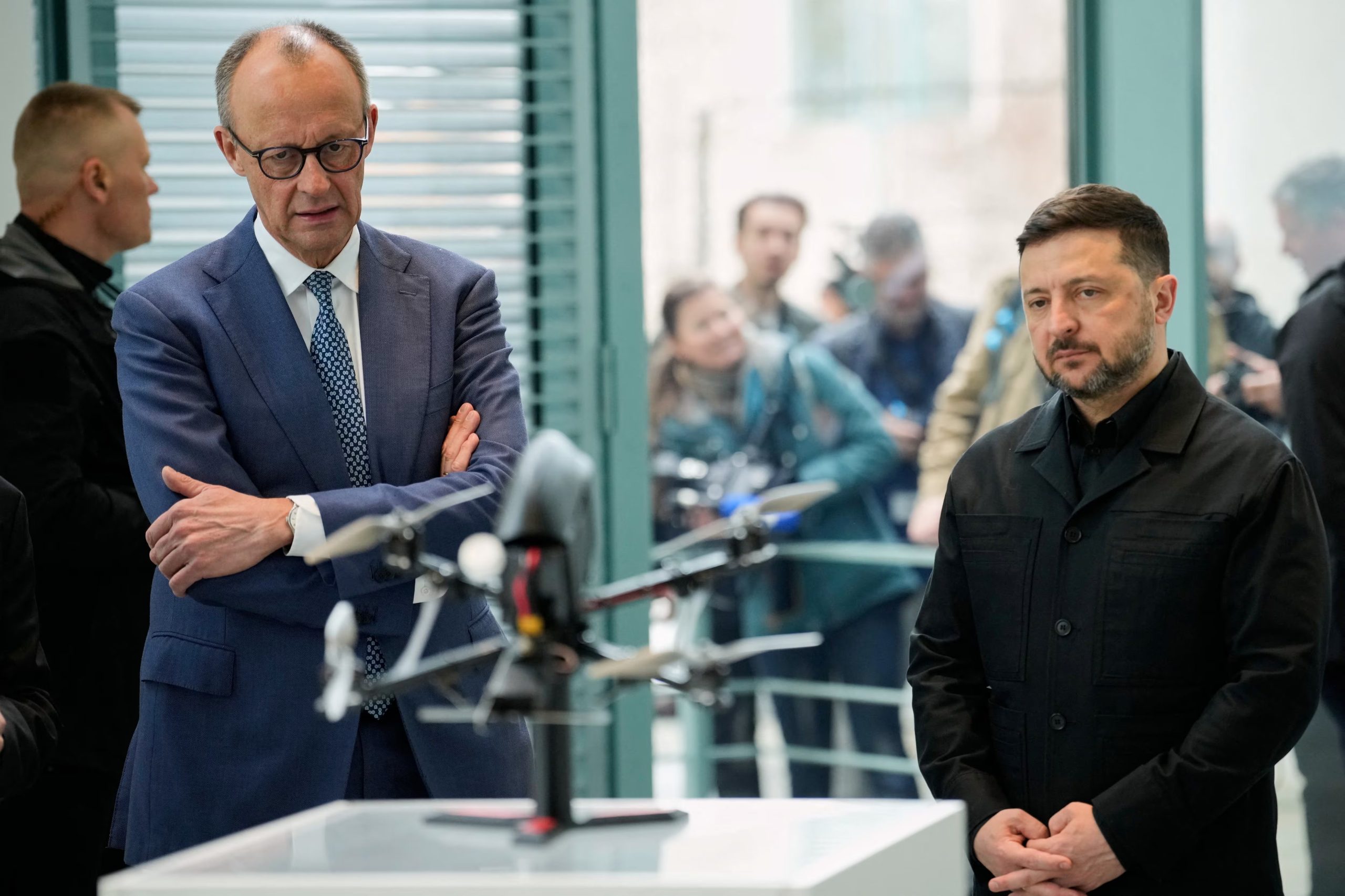 El canciller alemán Friedrich Merz y el presidente de Ucrania Volodímir Zelenski observan una presentación de drones fabricados en cooperación germano-ucraniana en Berlín, Alemania, el martes 14 de abril de 2026 (Reuters)