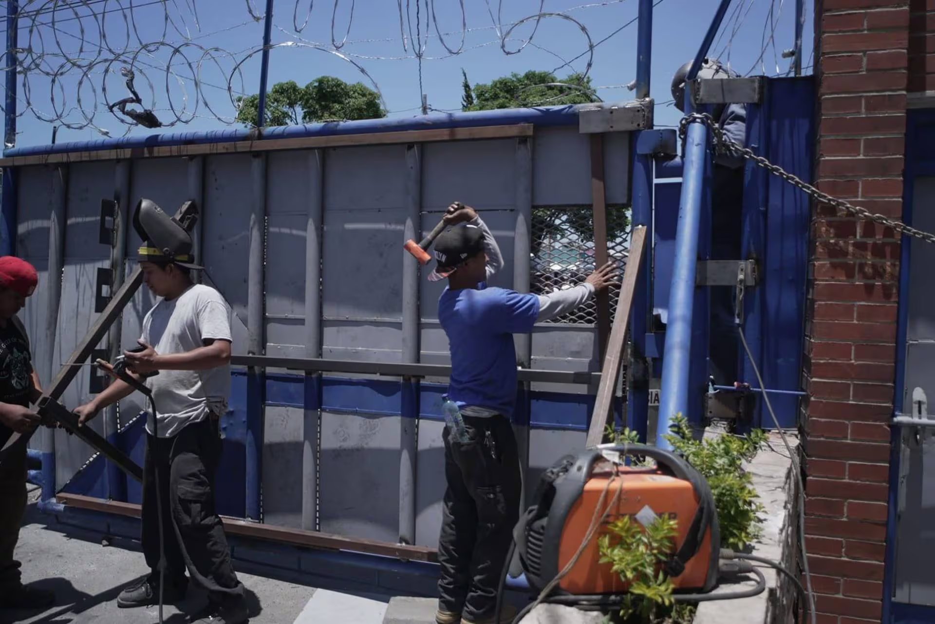 Trabajadores refuerzan las estructuras de los portones de ingreso a la Universidad de San Carlos de Guatemala con metal y alambre de púas, en medio de un clima de tensión. (Prensa Comunitaria)