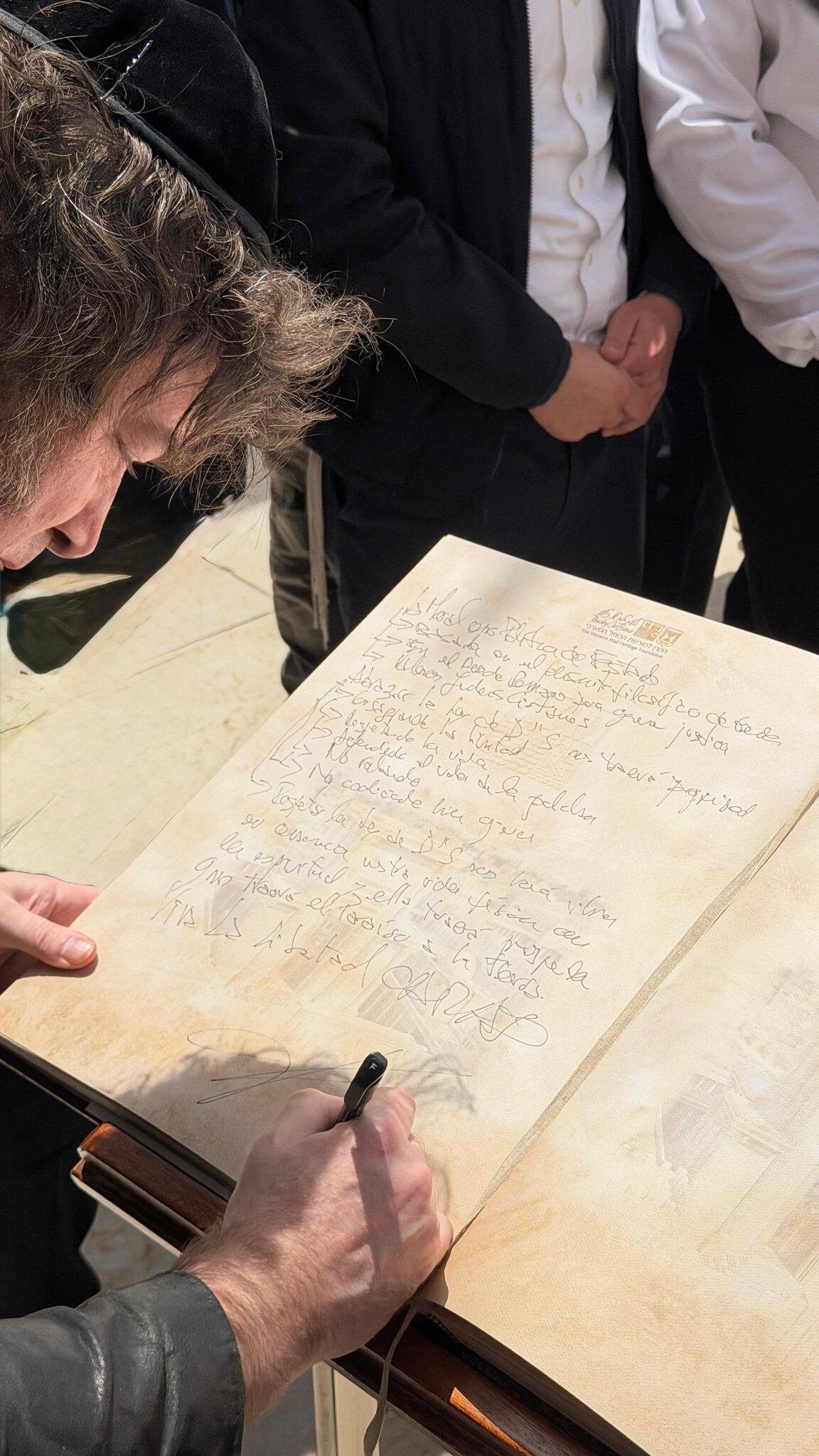 Javier Milei firma en el libro de visitas en el Muro de los Lamentos, un sitio histórico y cultural en Jerusalén. 