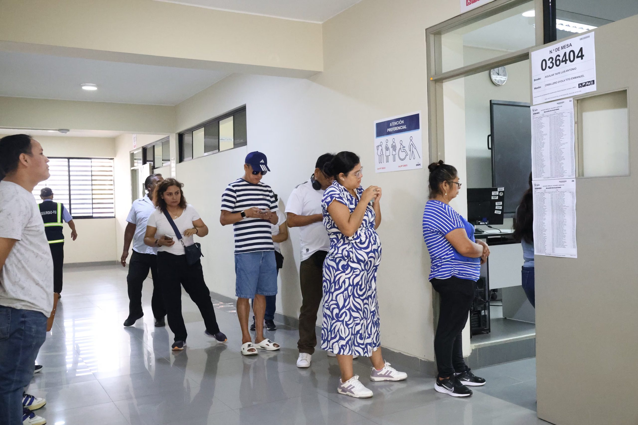 Personas de diversas edades y condiciones, incluida una mujer embarazada, aguardan su turno en una sala de espera donde se indica atención preferencial. (Paula Díaz Elizalde)
