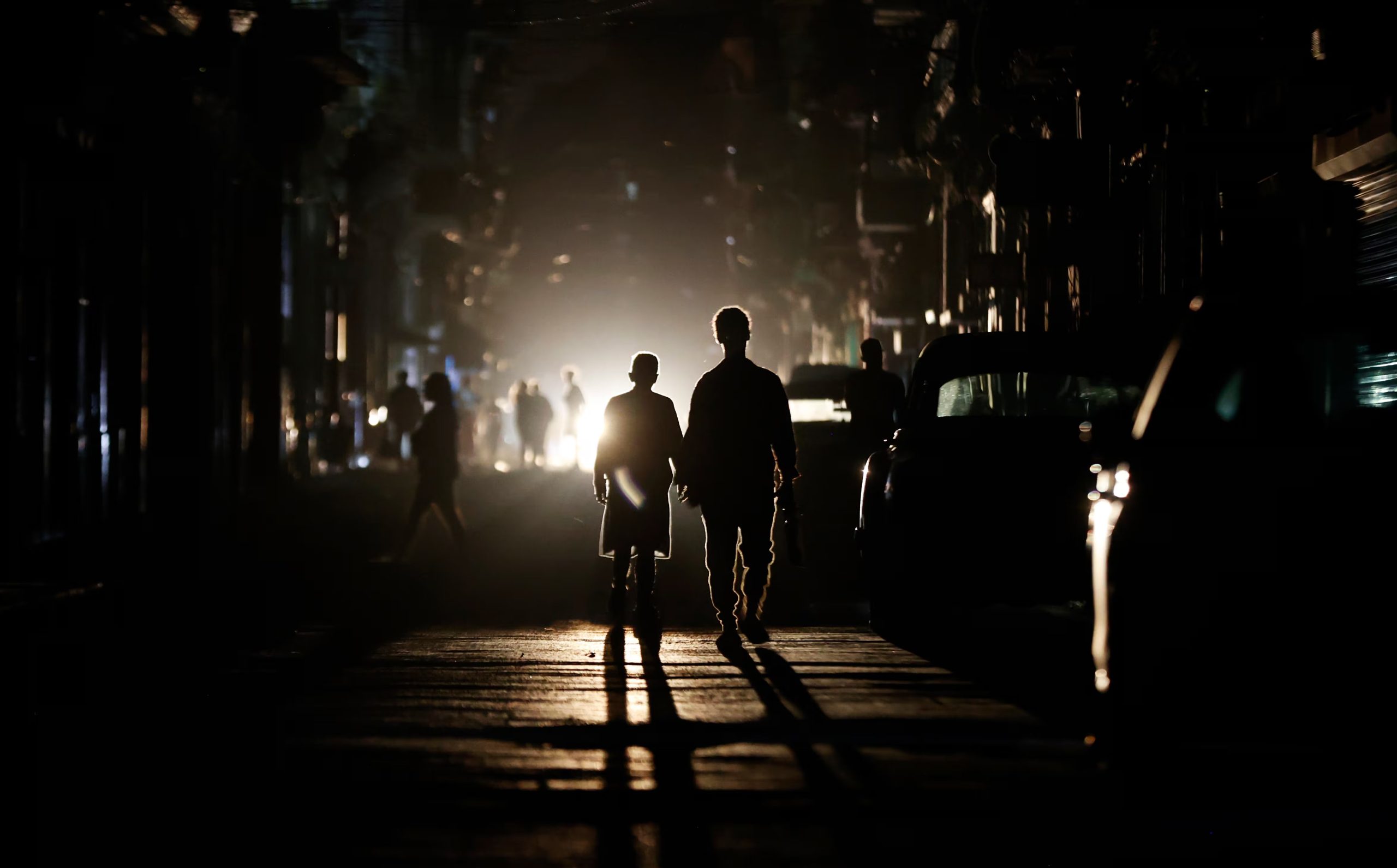Personas caminan por una calle sin electricidad, en La Habana (Cuba) (EFE/ Ernesto Mastrascusa/Archivo)