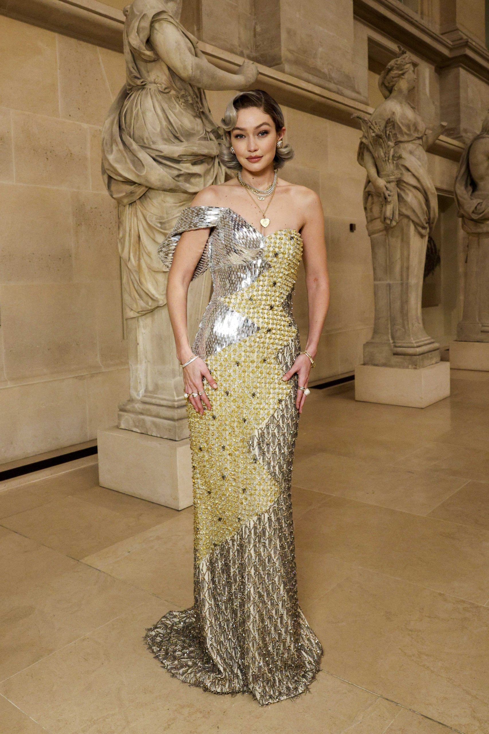 El vestido metálico de un solo hombro definió la silueta de Gigi Hadid y destacó por su efecto tridimensional y reflejos de luz sobre la pasarela (The Grosby Group)