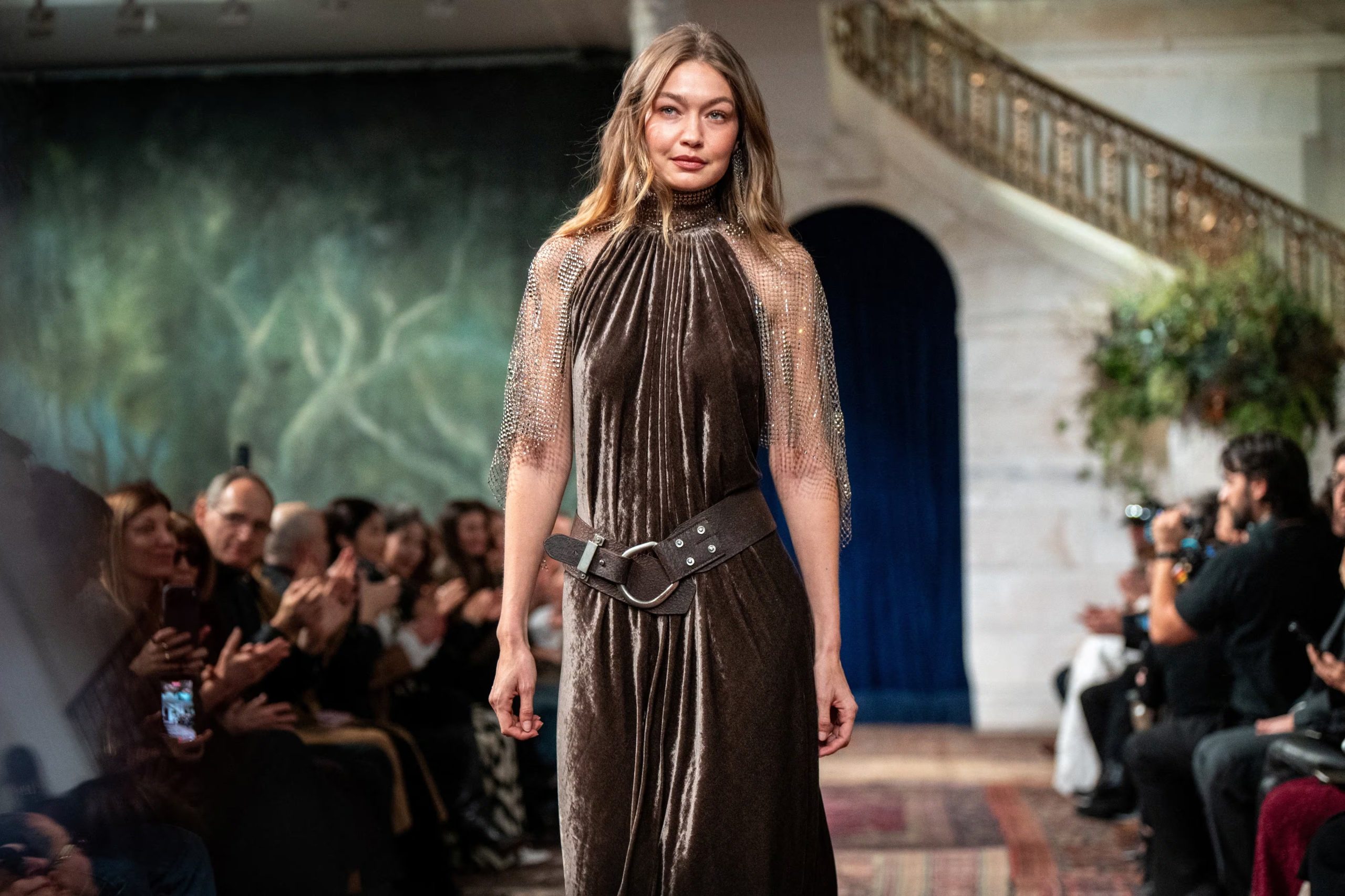 El vestido de terciopelo marrón, ceñido y con cinturón ancho, sumó sofisticación y movimiento a la colección de looks escénicos de Gigi Hadid (REUTERS/Angelina Katsanis)