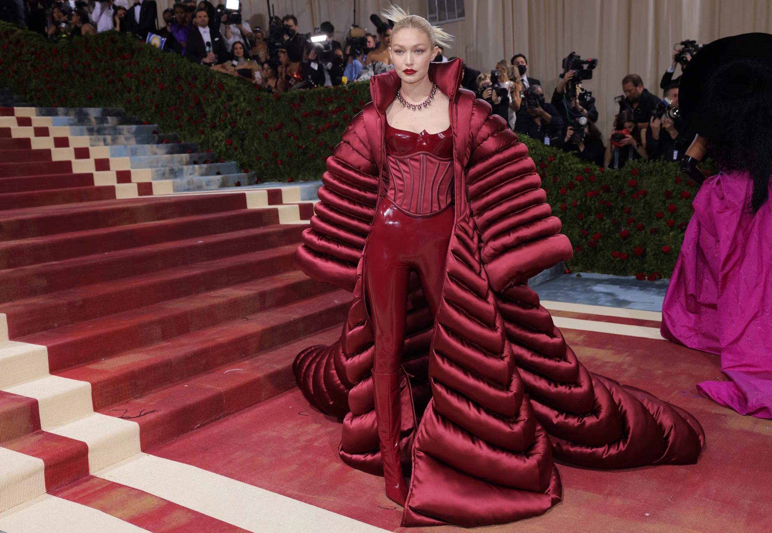 El conjunto rojo de vinilo y el abrigo acolchado de volumen extremo cerraron con impacto uno de los desfiles más comentados de la carrera de Gigi Hadid (REUTERS/Andrew Kelly/File Photo)