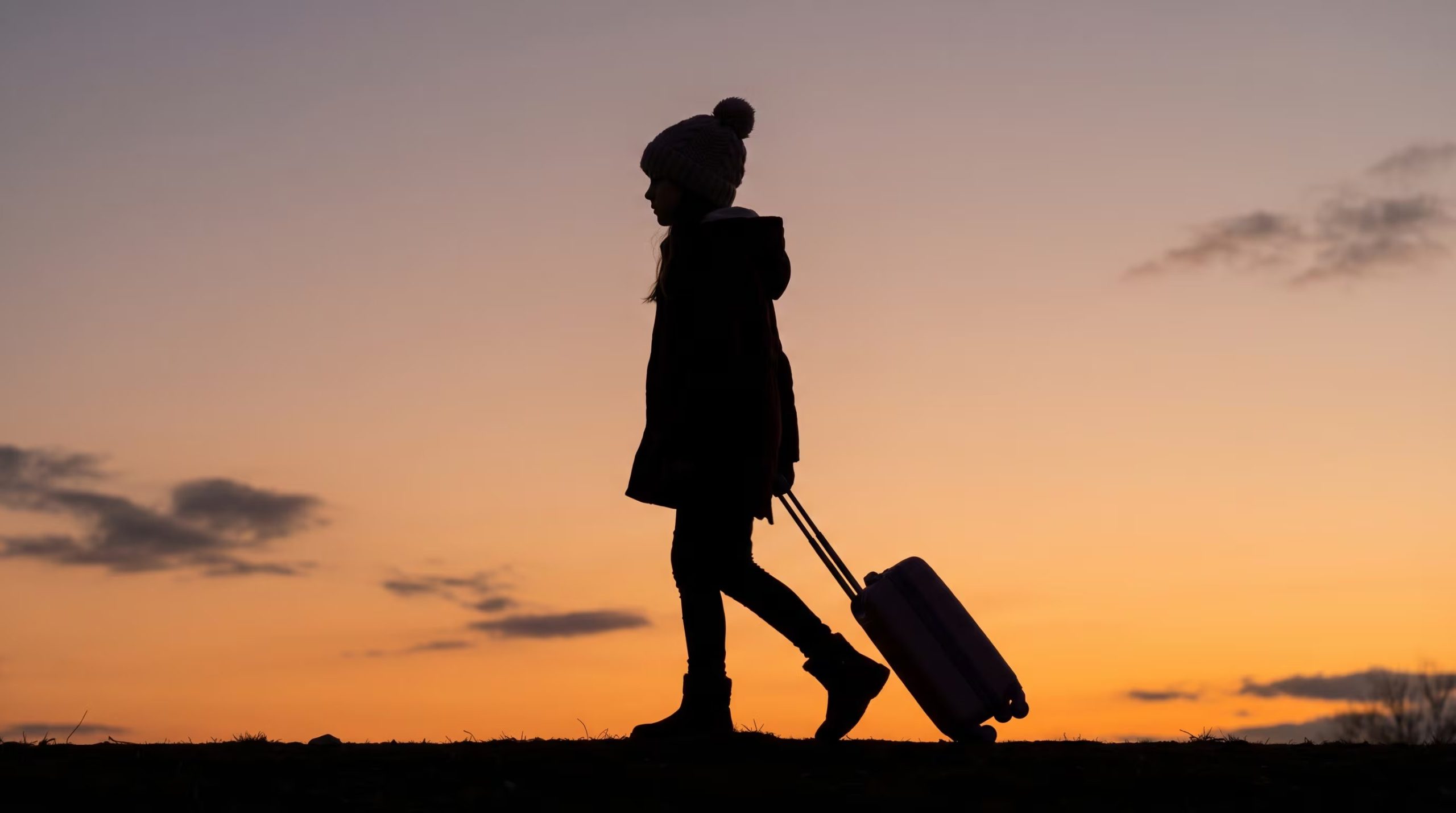 La silueta de una niña de 11 años con leucemia, llevando una maleta, avanza en el horizonte al atardecer, representando su valiente recorrido. (Imagen Ilustrativa Infobae)
