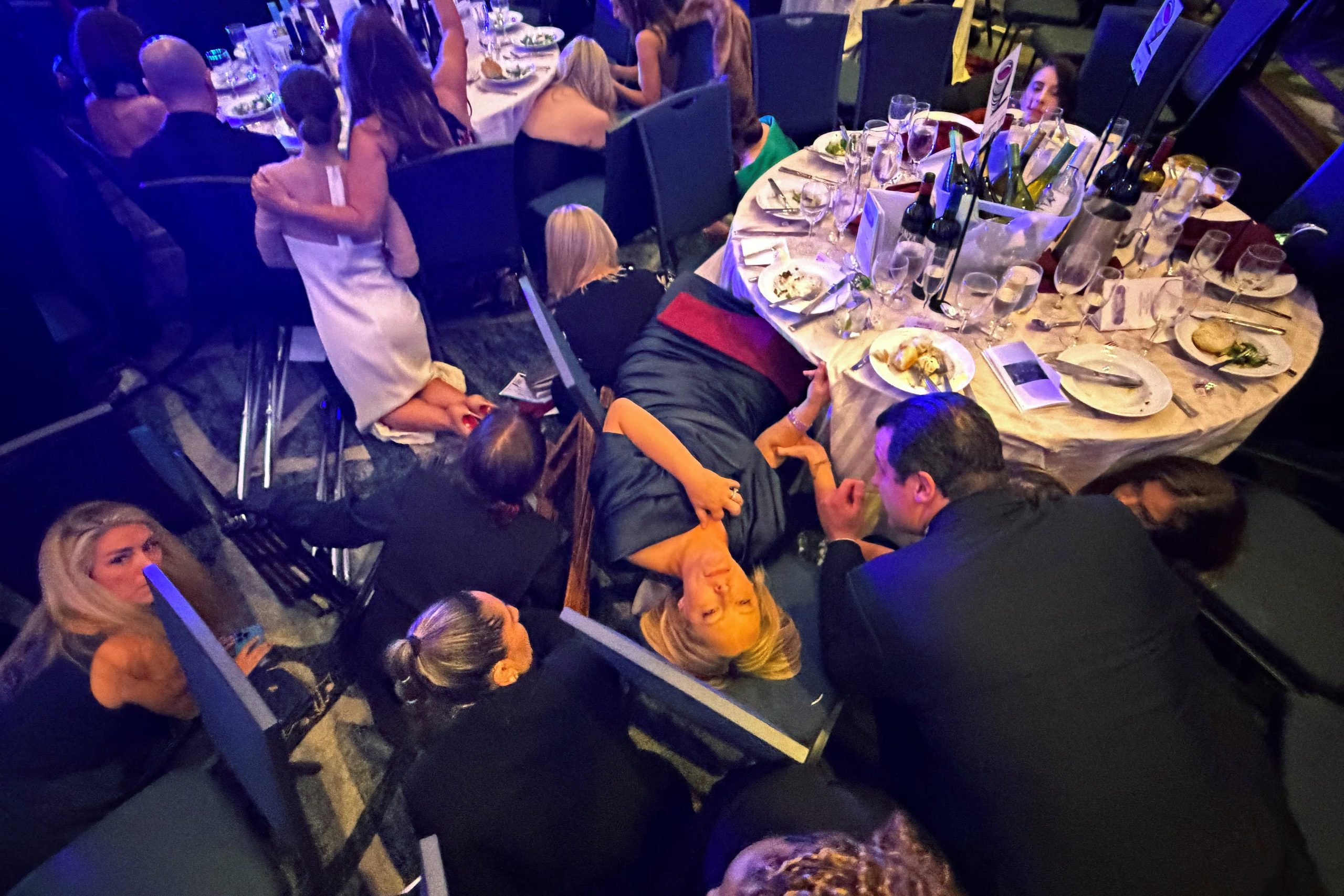 Los invitados se ponen a cubierto después de que el presidente de Estados Unidos, Donald Trump, y la primera dama, Melania Trump, fueran evacuados de la cena de la Asociación de Corresponsales de la Casa Blanca por agentes del Servicio Secreto cuando un hombre abrió fuego con una escopeta contra el personal de seguridad fuera de la sala, en Washington, D.C., Estados Unidos, el 25 de abril de 2026. Fotografía tomada con un teléfono móvil. REUTERS/Evan Vucci