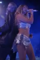 El conjunto plateado asimétrico, con top y minifalda de textura metálica, refleja la faceta más futurista y vanguardista de Karol G en el festival (Captura de video)