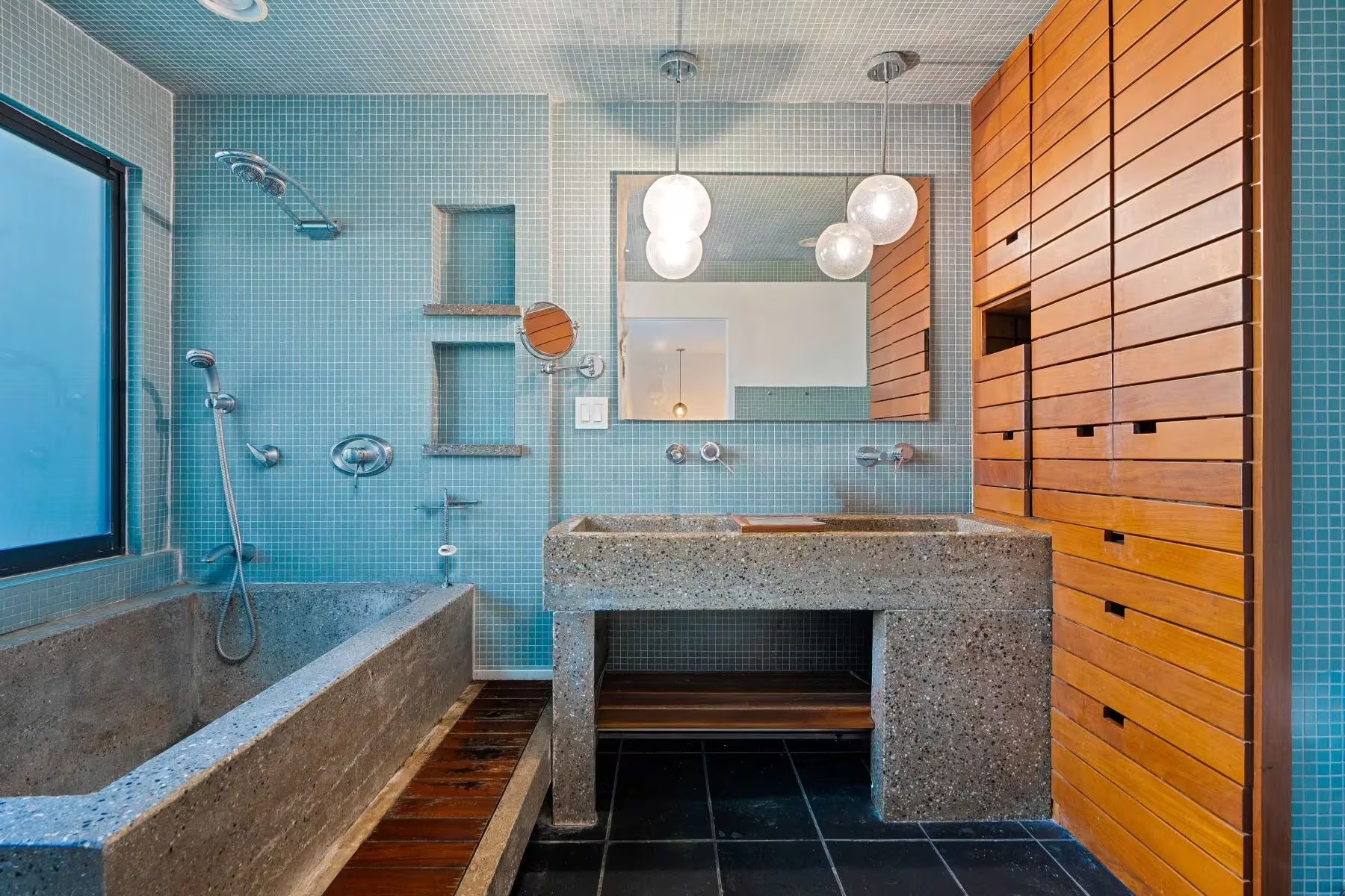 El baño principal presenta azulejos azules en las paredes y detalles de madera, lo que contribuye a un contraste destacado en el ambiente. Foto: sothebysrealty.com
