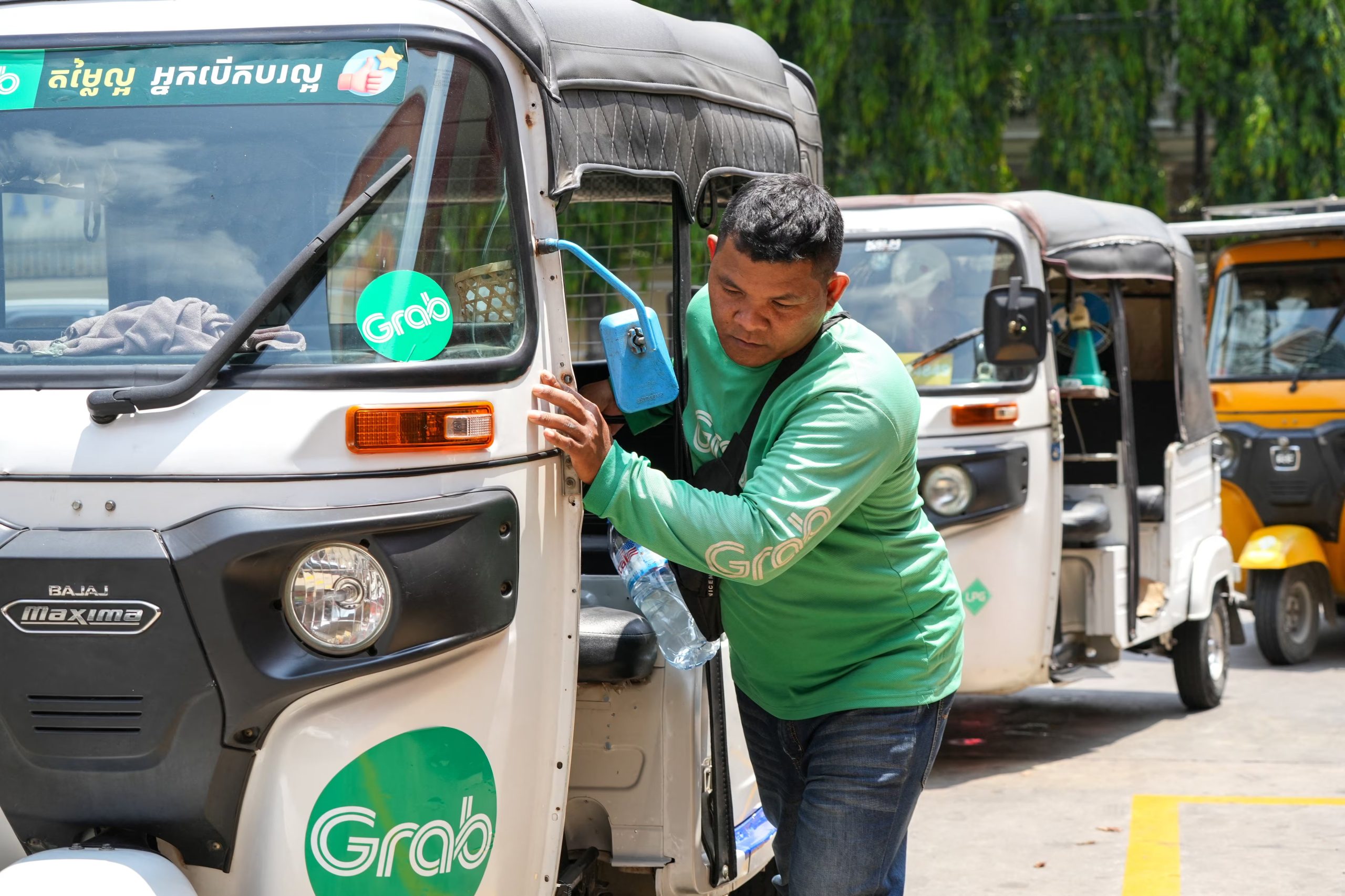 Un conductor de tuk-tuk empuja su vehículo mientras hace fila para llenarlo de GLP y gasolina en una gasolinera, en medio del conflicto entre Estados Unidos e Israel con Irán, en Phnom Penh, Camboya. REUTERS/Roun Ry