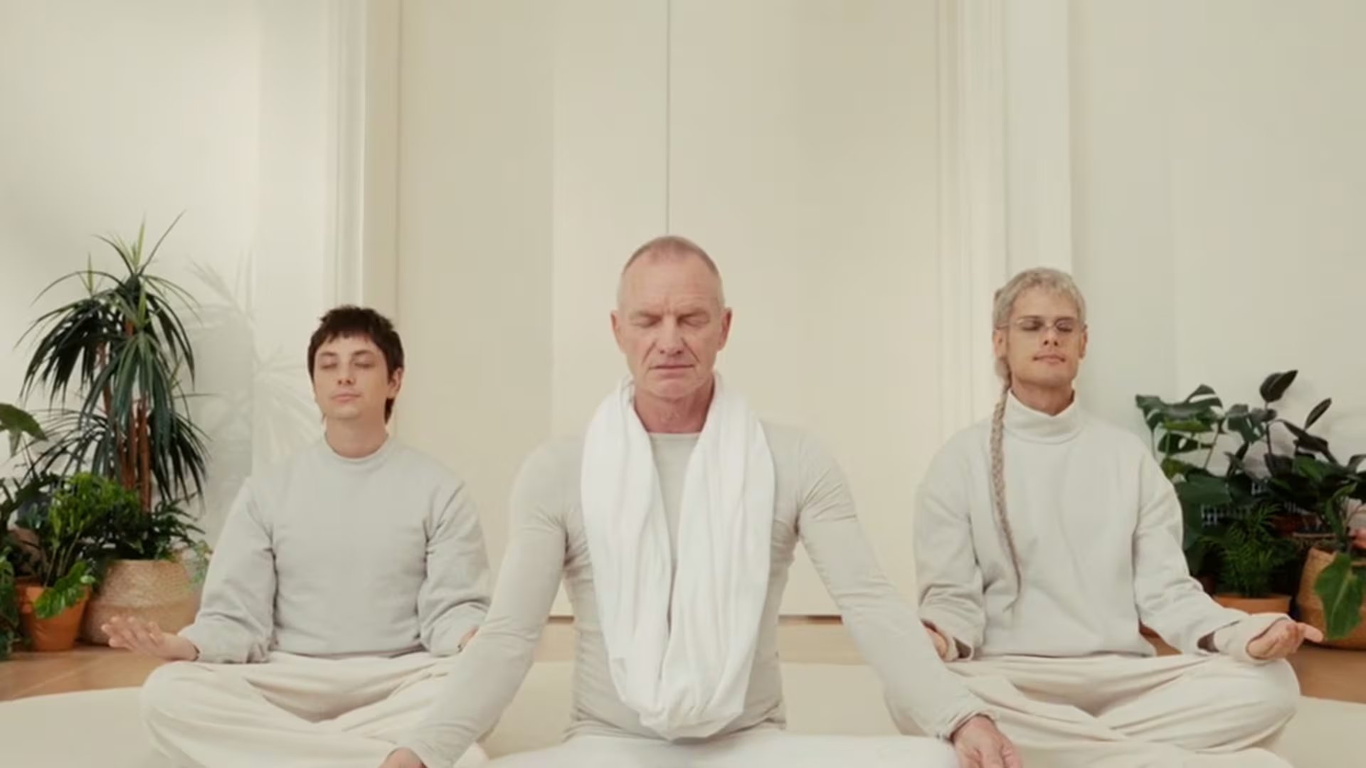 Sting, Ca7riel y Paco Amoroso sentados en el suelo en posición de meditación. (YouTube)