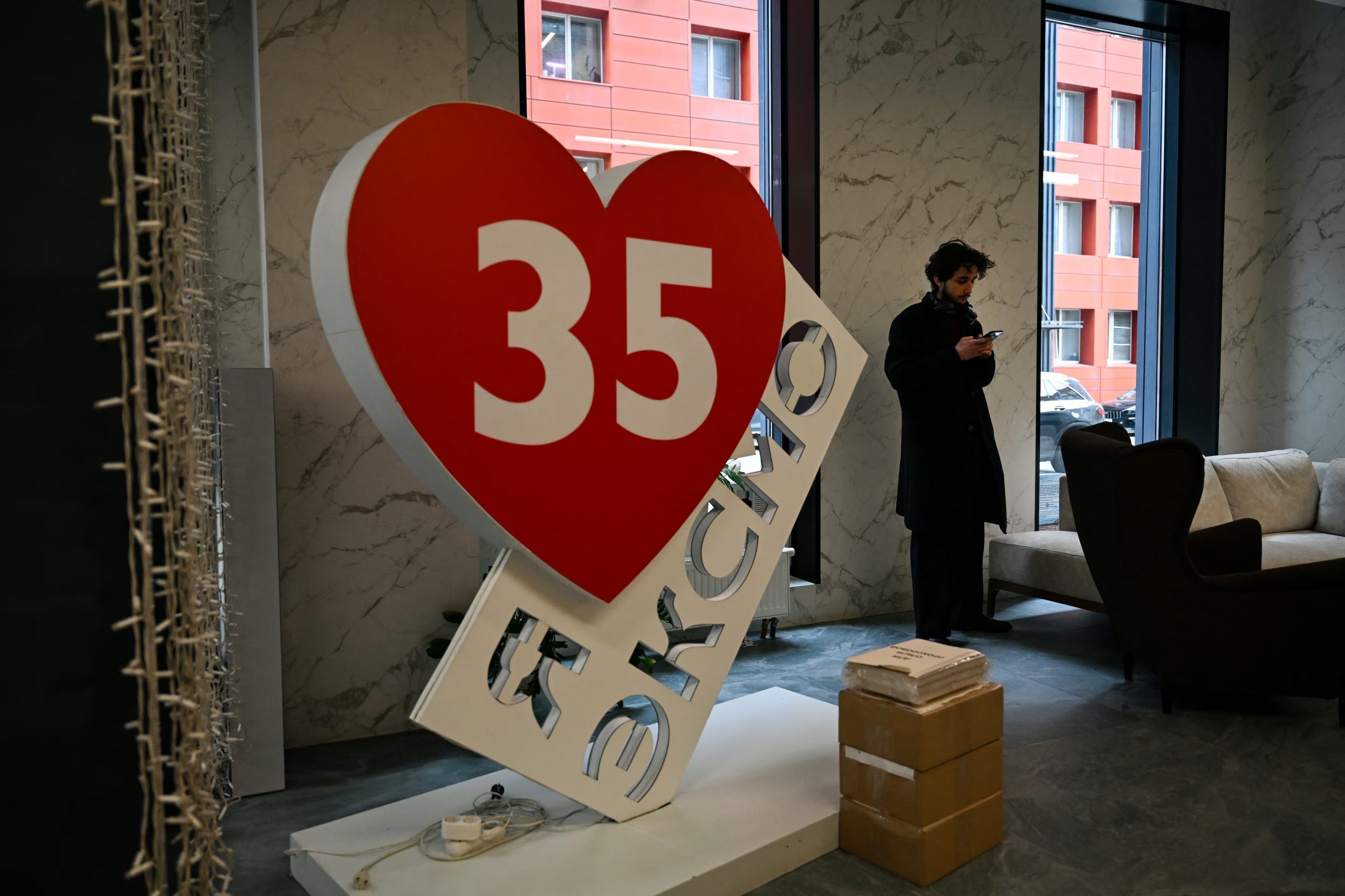 Un hombre utiliza su teléfono en el vestíbulo de la sede central de Eksmo en Moscú, el 21 de abril de 2026. El Tribunal Supremo ruso declaró extremista al movimiento LGTBI en noviembre de 2023, abriendo la puerta a aplicar legislación antiterrorista a cualquier expresión de identidad relacionada. (Igor Ivanko/AFP)